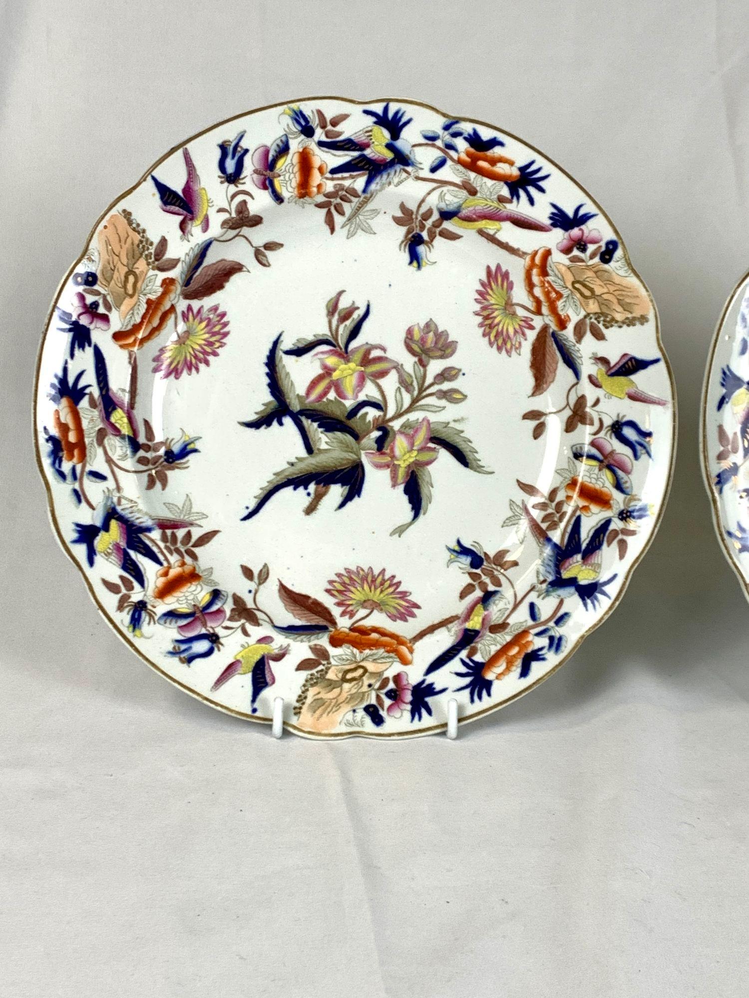 This pair of dishes feature a lively design of waterlilies and songbirds in a lovely array of colors.
The flowers are painted in shades of pink, yellow, and green, while the stems and leaves are adorned with gilt, deep blue, and grey.
The border is