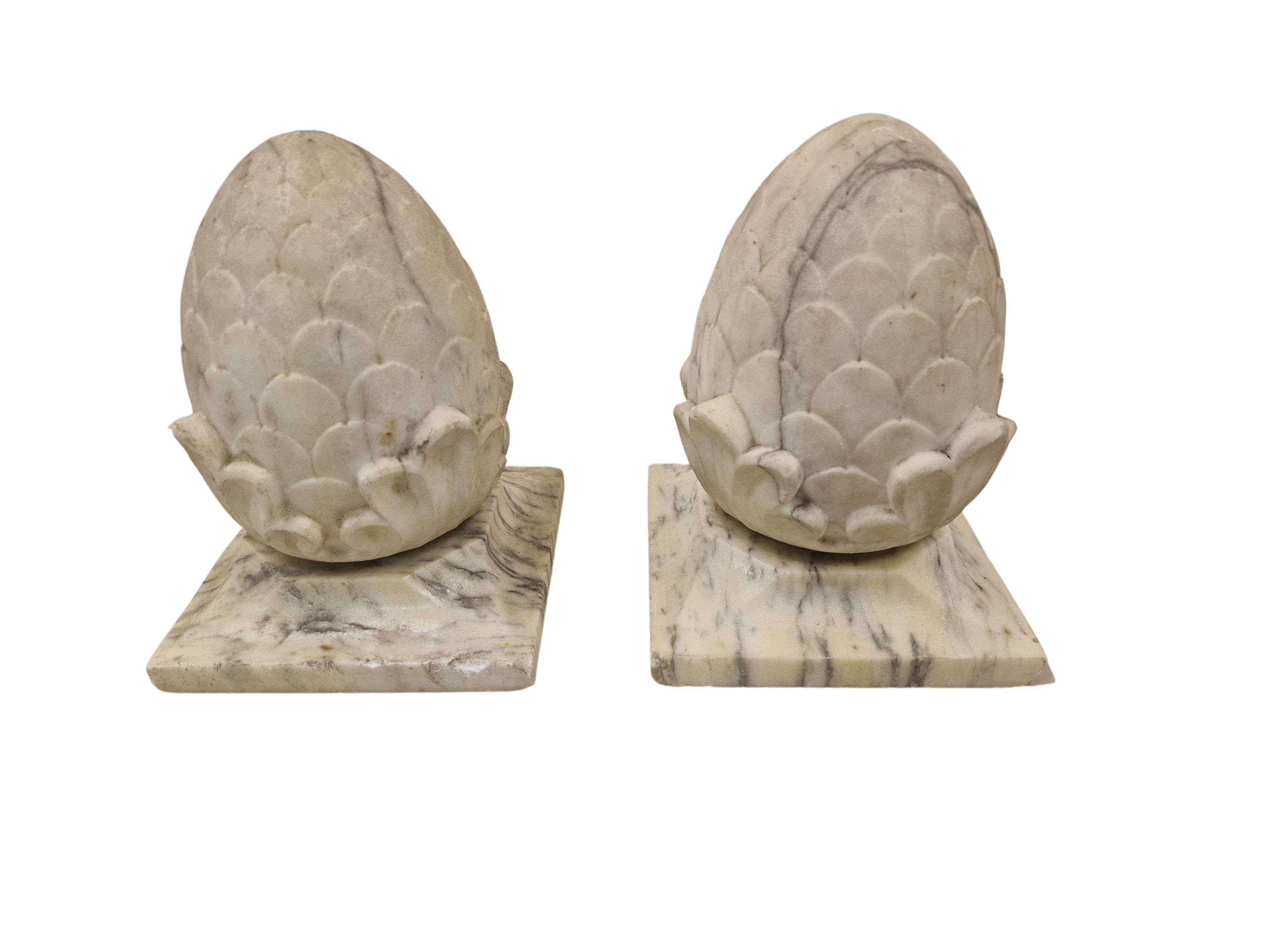 A pair of wonderful, antique column crowns, decorative objects, hand-made in Italy, around 1920, in the Art Deco period, based on an antique model.

On a square marble base there is a central pine cone, also made of marble. The basic color of the