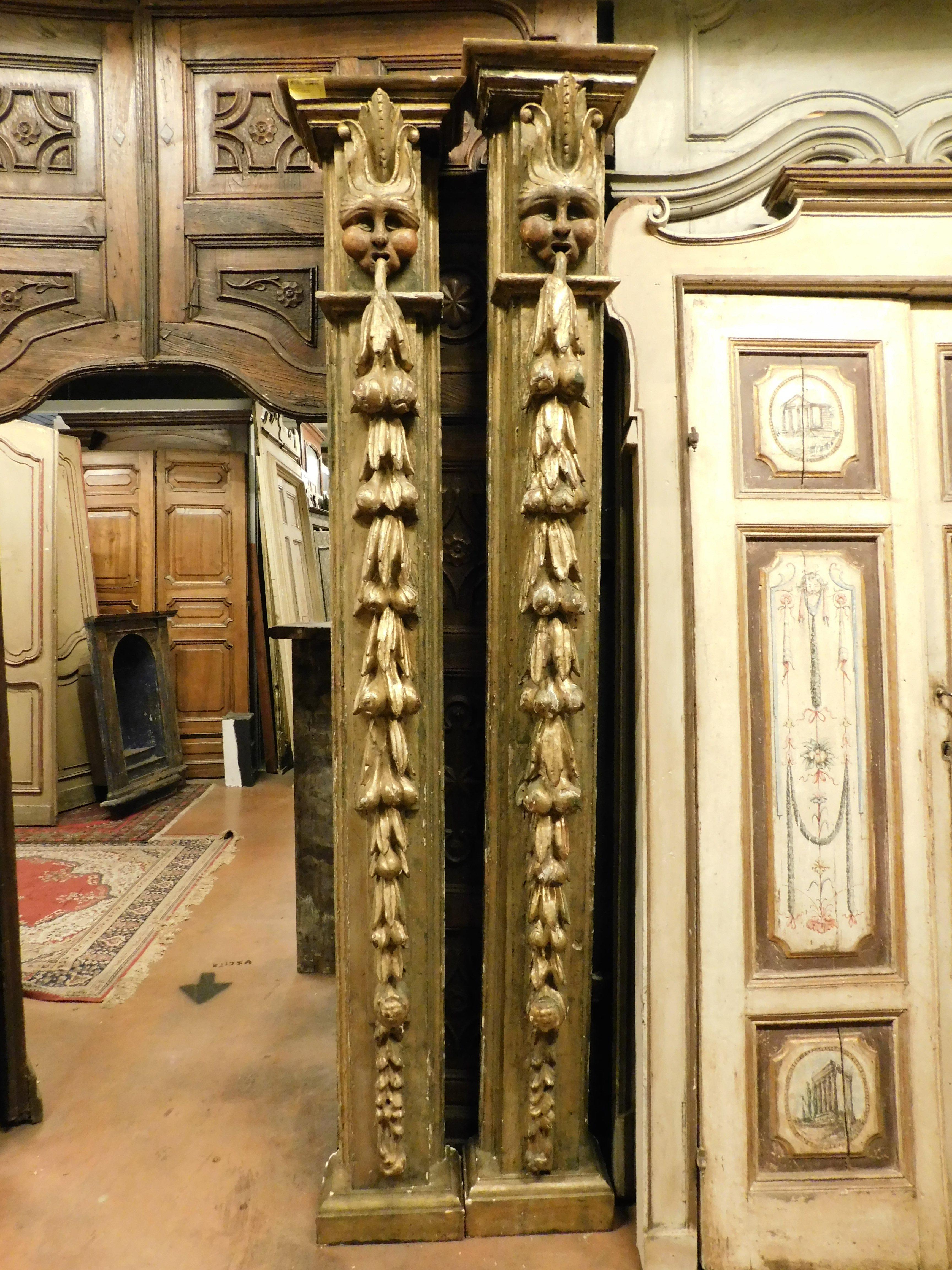 Ancienne paire de colonnes en bois massif de peuplier doré, peintes et sculptées à la main avec des détails de masques, dos creux pour alléger le poids, construites à la main par un artisan et artiste du 18ème siècle, d'Espagne, d'une grande