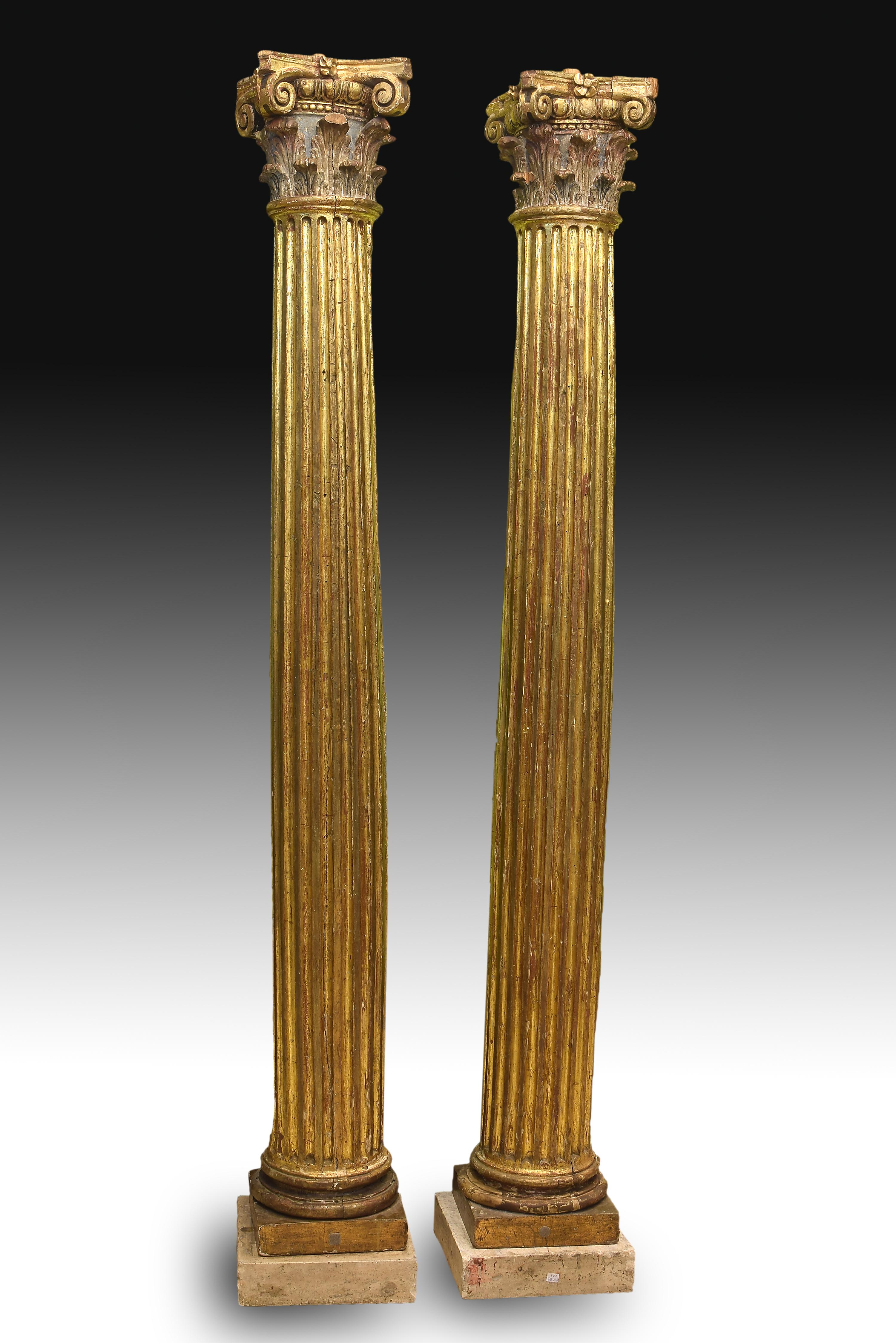 Pair of carved columns that have been left barely sketched and without polychrome or gilding on the back (something that would indicate their were part of a church altarpiece). Both practically equal, each one has a small square pedestal that
