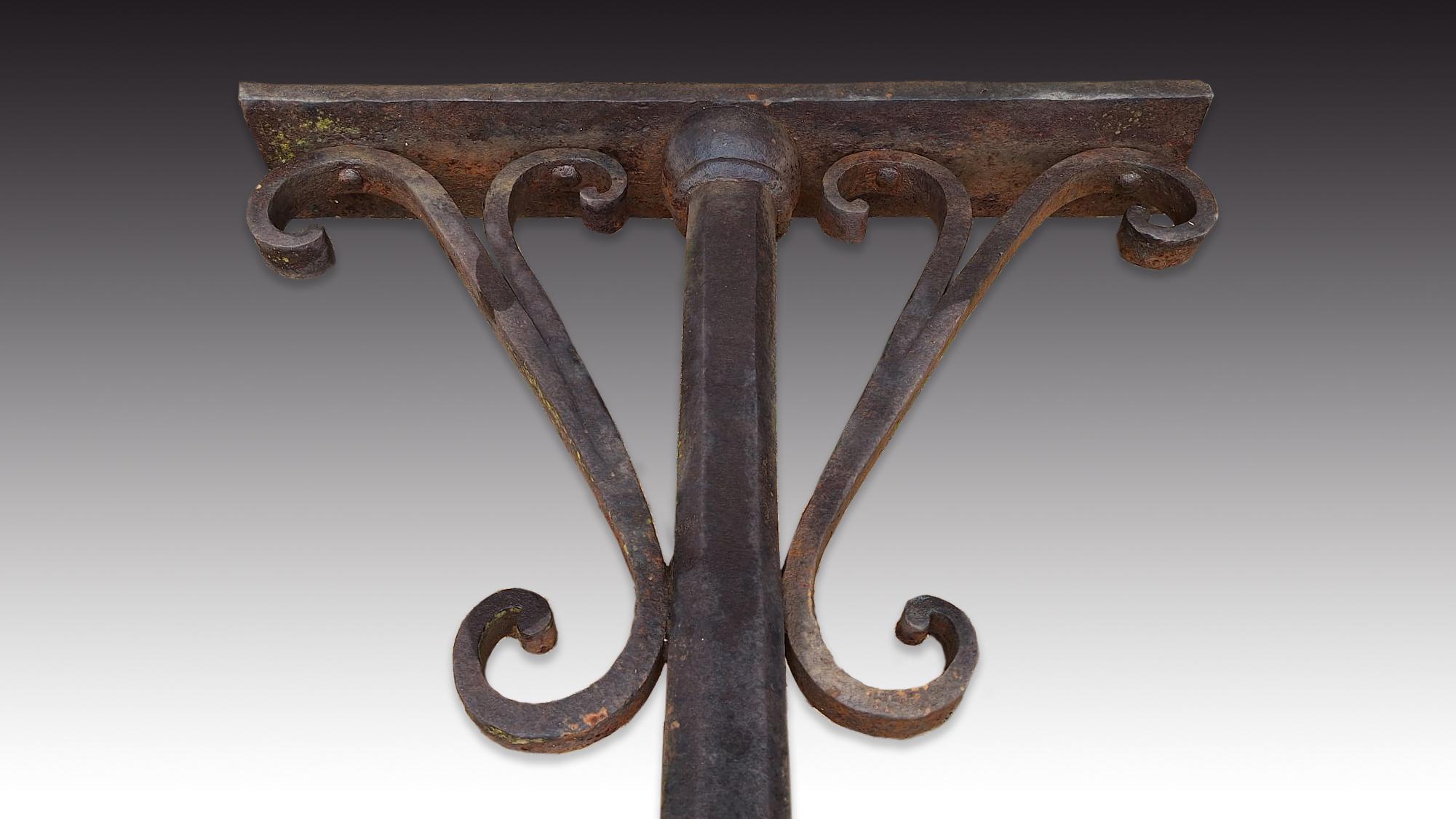  Pair of columns. Wrought iron. Possibly Spanish school, 17th century. 
Pair of architectural supports made of iron with a polygonal central axis, ending in a spherical shape on one side and in a support for a horizontal crossbar on the other. At