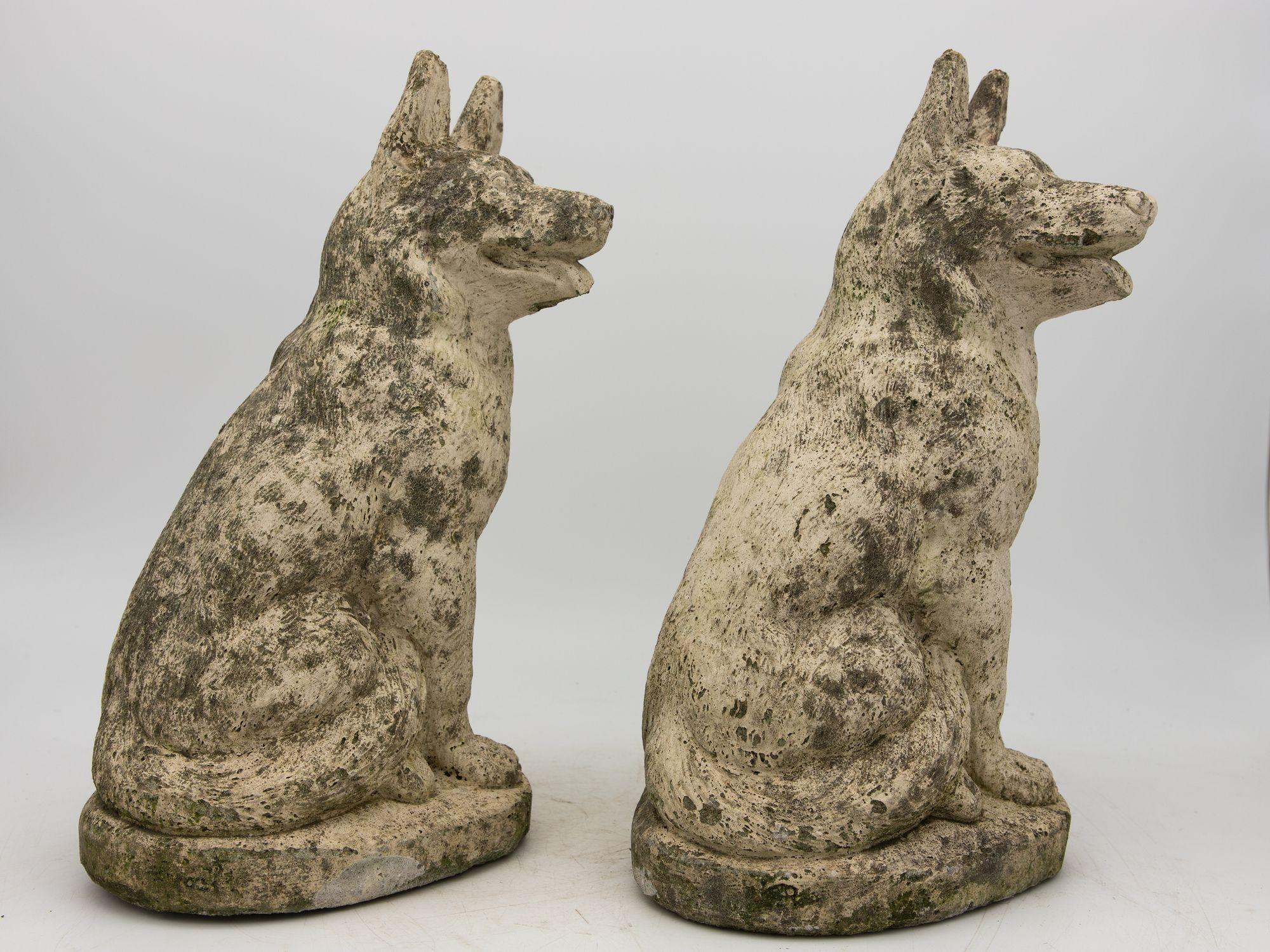 This exquisite pair of mid-20th-century concrete dogs, painted in a weathered white finish, exudes timeless elegance with an honest patina. Crafted in England, they take the form of small shepherds, their alert expressions beautifully captured with