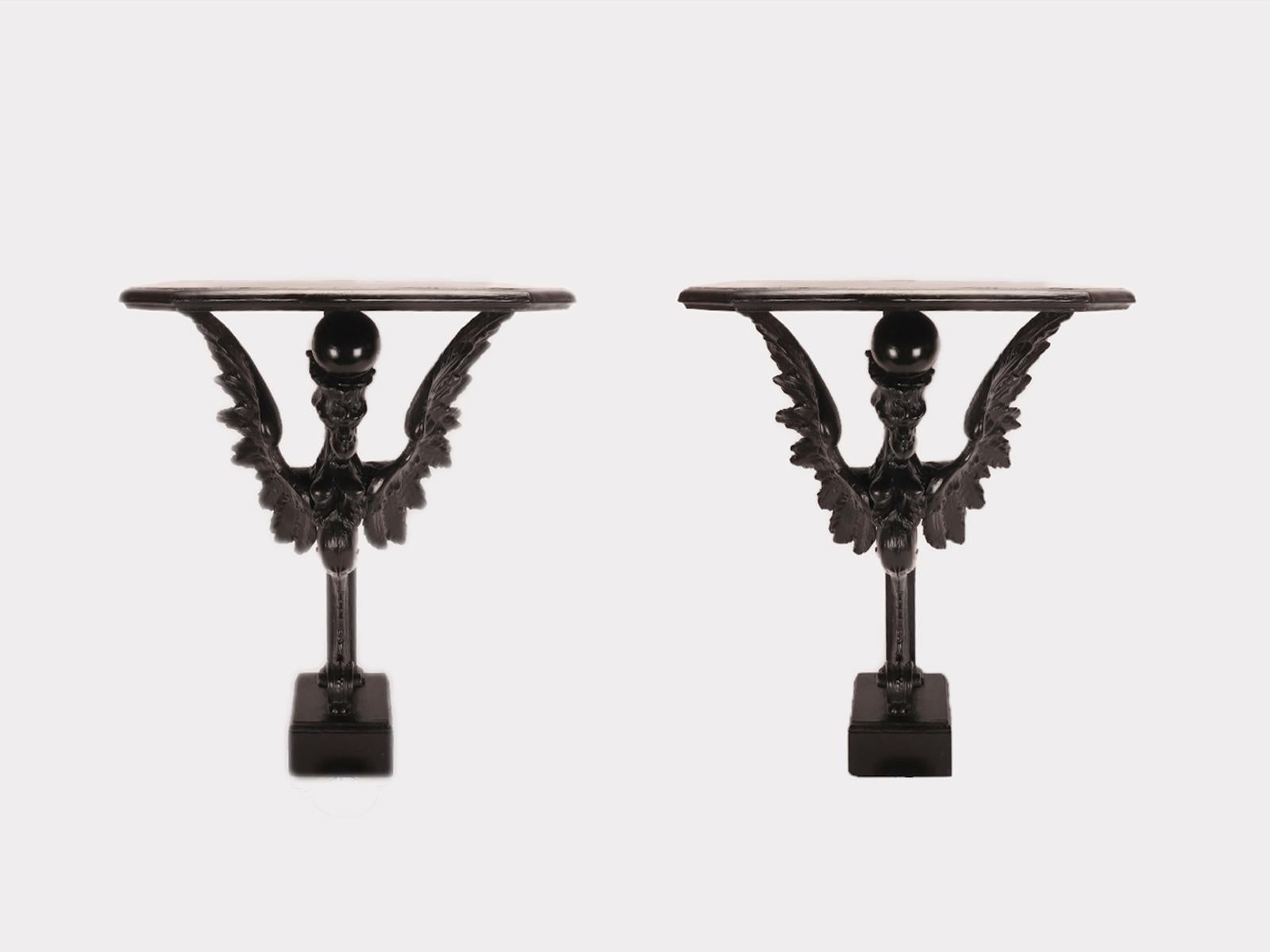 The pair of console tables is made of walnut wood for the sculpted and carved parts, while the structural parts are made of ebonized fruit wood. The foot has a square plan with an owl's beak frame at the top and a flat surface. In the center is the