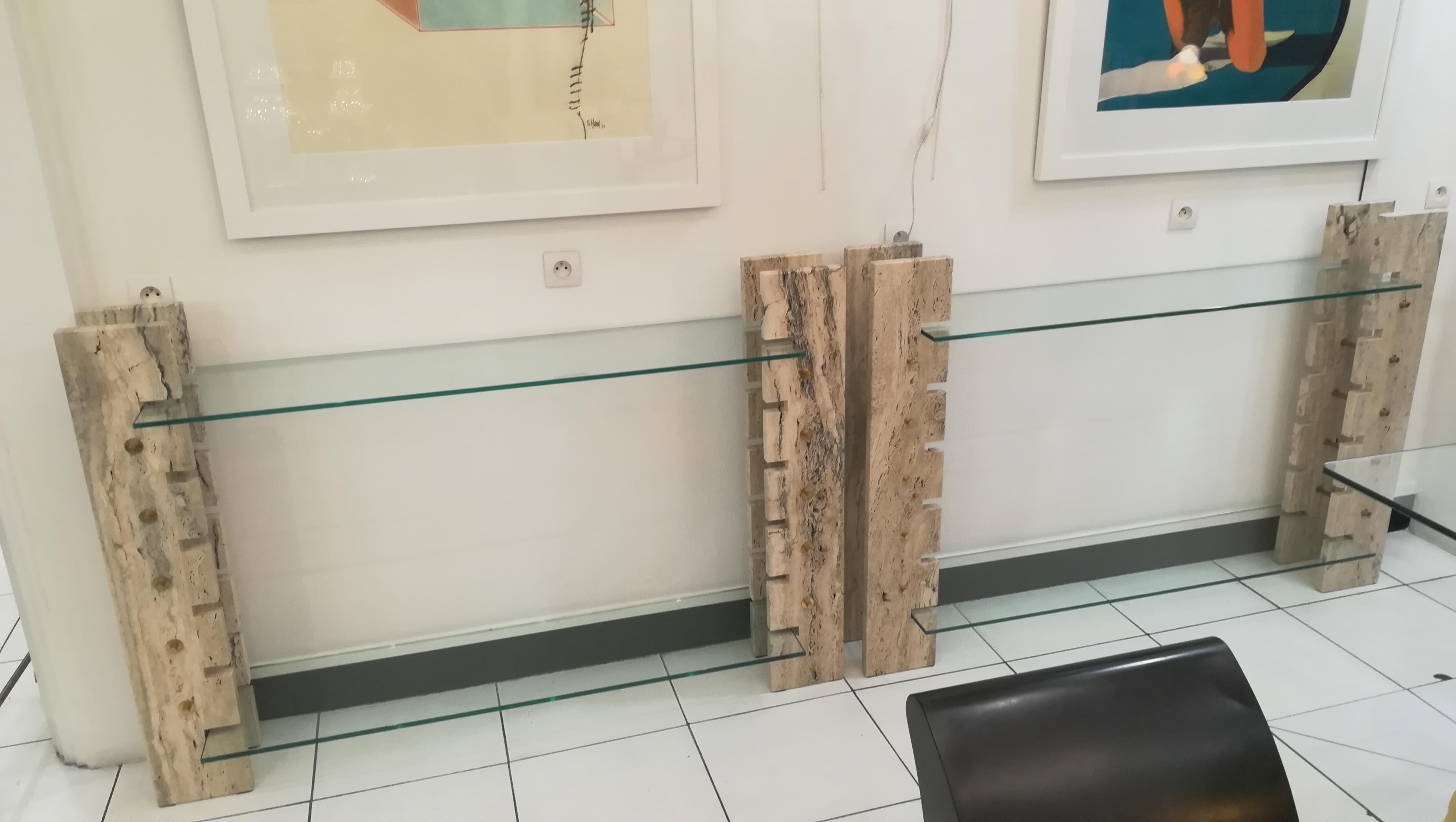 Pair of consoles or book holders in travertine and glass, circa 1970
Measures: 146 each one, height of the top glass: 85cm
(the brass screws are slightly different on each console, cf photos)
can be sold separately upon request.