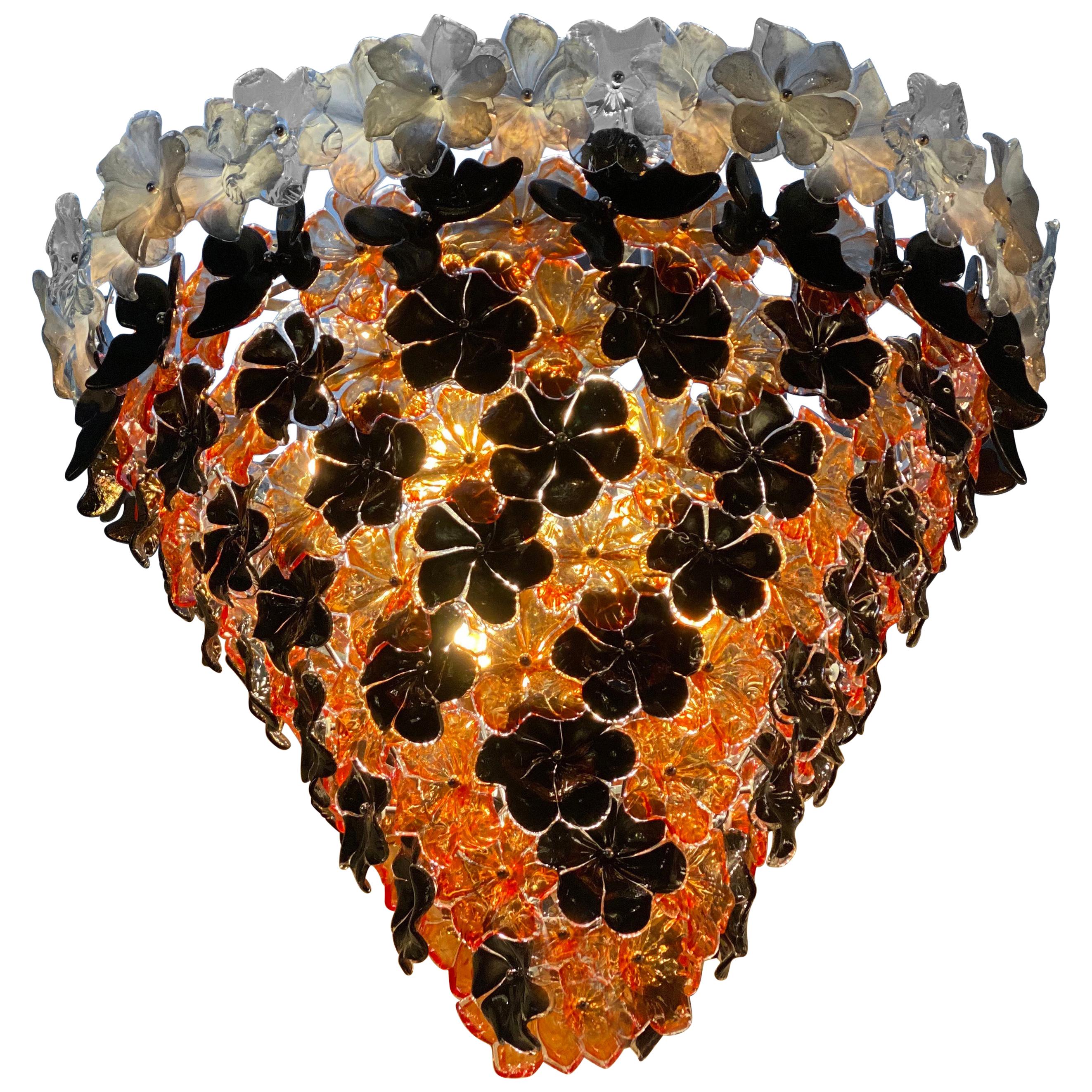 Auffälliger zeitgenössischer Kronleuchter aus Muranoglas, bestehend aus Dutzenden von schwarzen, orangefarbenen und weißen mundgeblasenen Blumen von Galleria Veneziani.
Auch als Paar erhältlich.