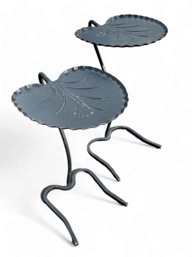 Pair of Contemporary Cast Iron Lily Pad Nesting Tables. Thin metal Lilly with a metal legged frame. Light and small foot print to any area.

Small nesting table measures 19 inches high