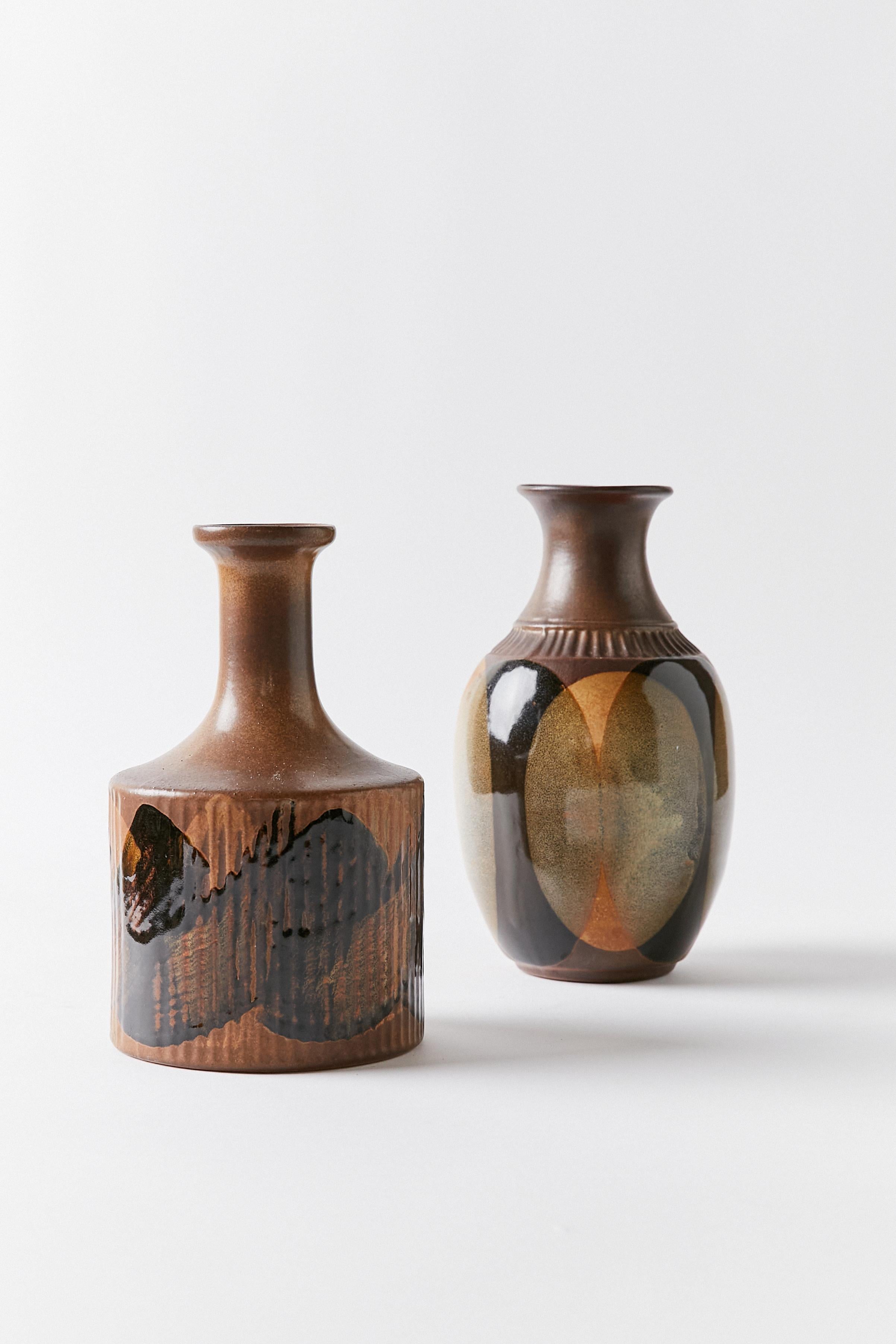 Set of two contemporary ceramic vases decorated in different shades of brown, black, dry green and ochre.

Vase 1
Height 10 in / 25.4 cm
Width 6 in / 15.24 cm
Depth 6 in / 15.24 cm
Vase 2.
Height 9.25 in / 23.50 cm
Width 5.5 in / 13.97
