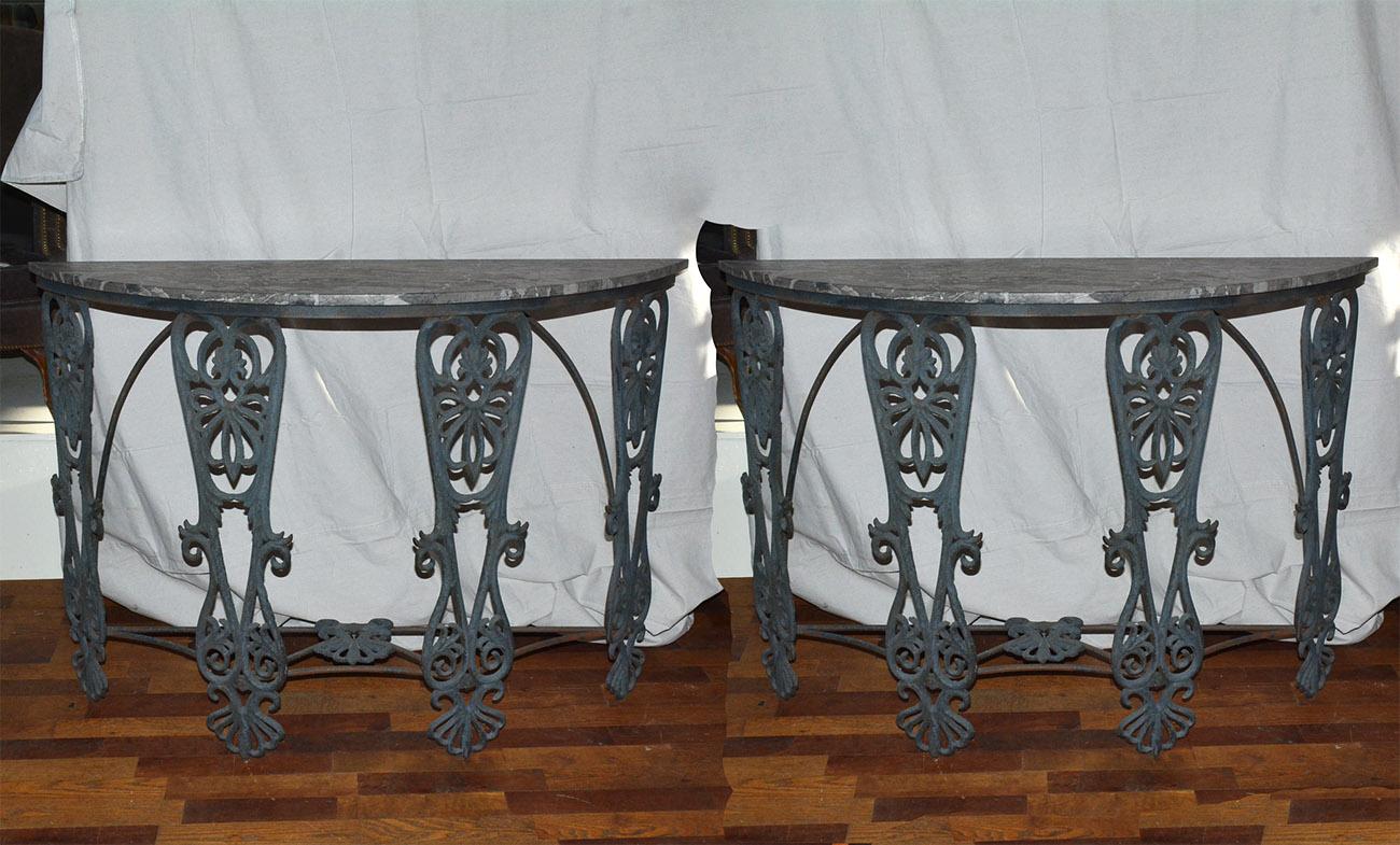 A pair of stunning contemporary Egyptian Revival style demi lune console tables with iron base and a beautiful gray marble top. The metal elements on the base resembles that of Egyptian hieroglyphics giving it an added dimension of interest.
The