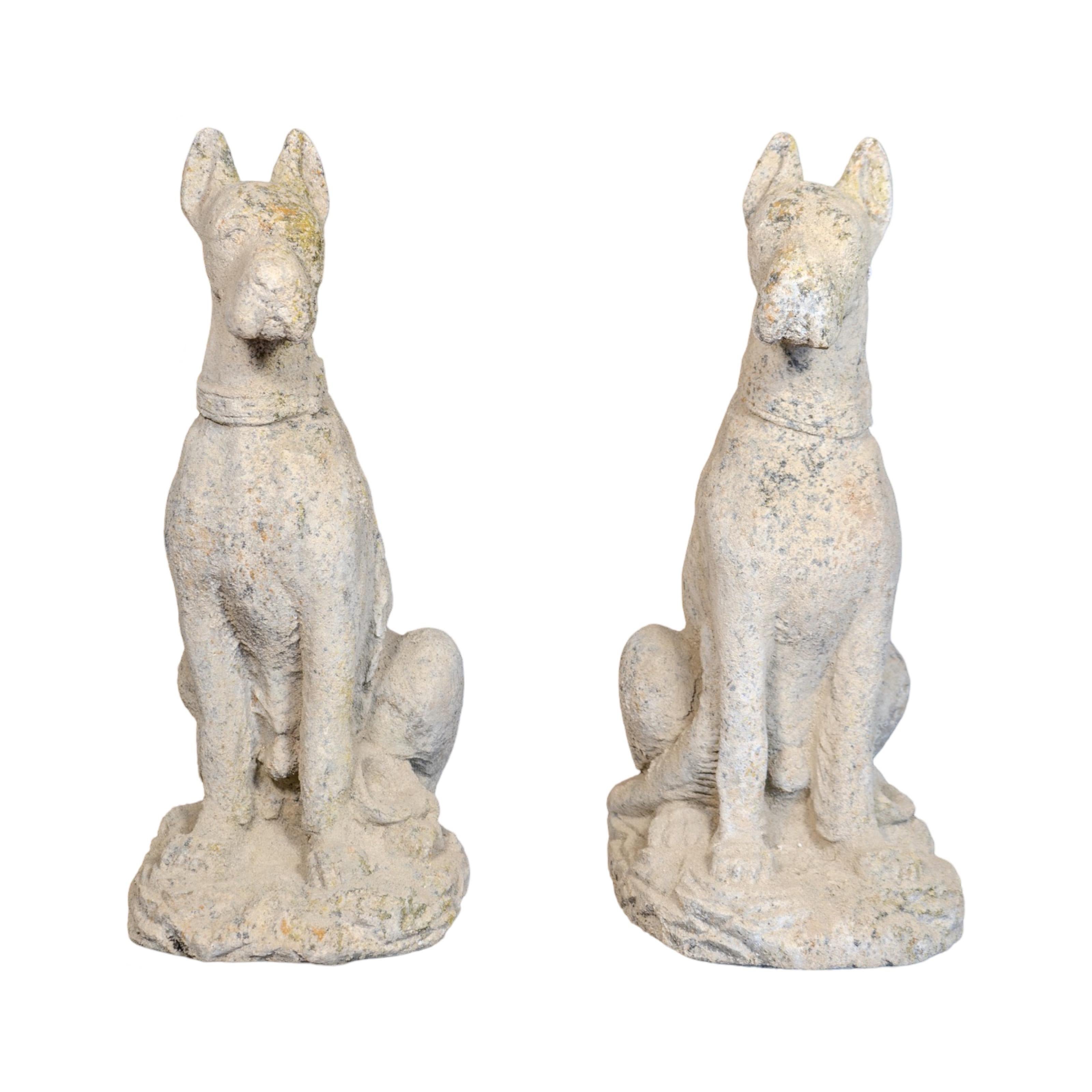 A pair of contemporary Boxer dog sculptures from France, crafted from a granite composite with a naturally weathered finish. Sold as a set, they make a bold and charming addition to any outdoor space.