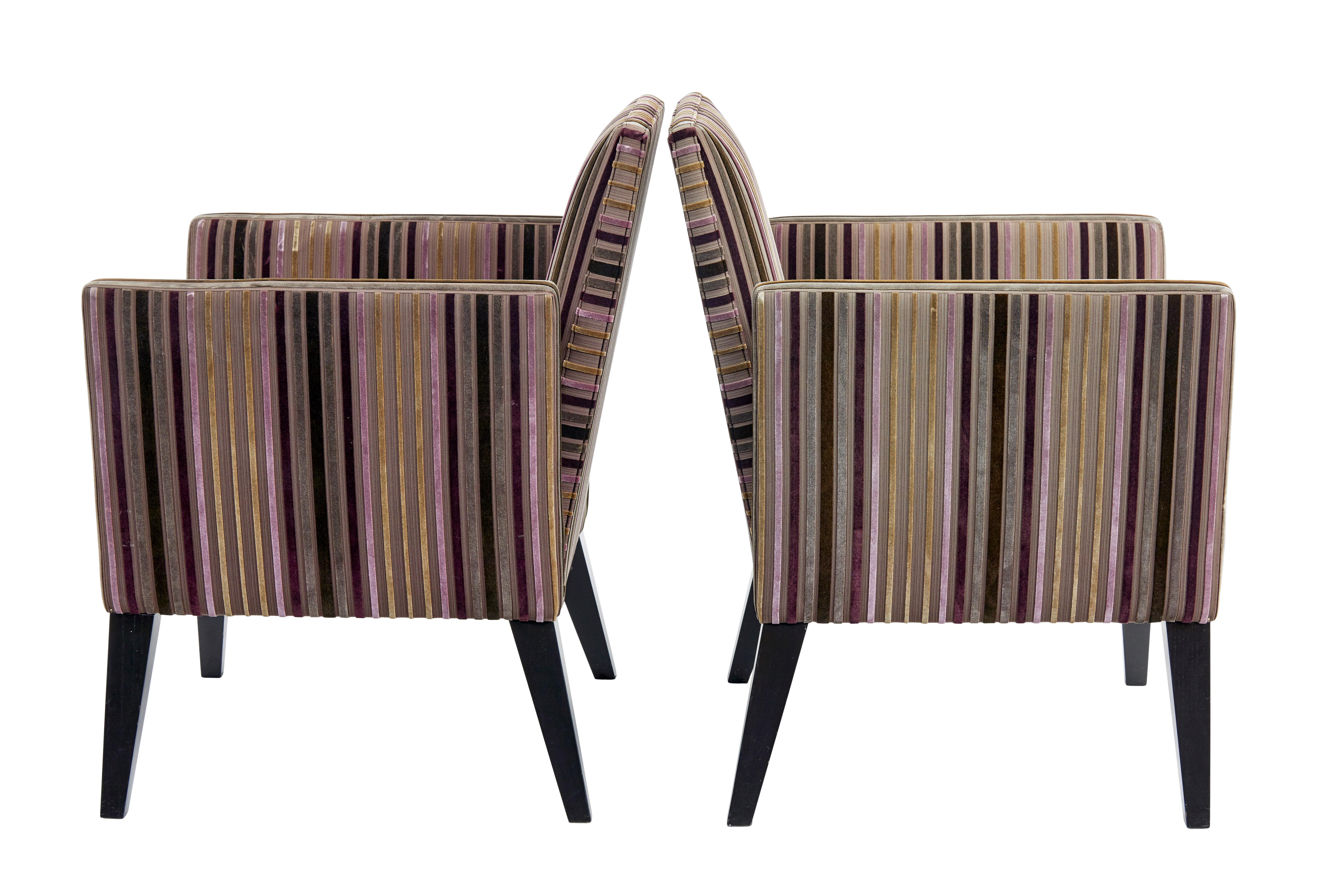 Stylish and elegant pair of contemporary armchairs.

Straight back with a fixed drop arm construction allowing  the open back design.  Standing on stained black ash tapering legs.

Some minor marks to fabric, from compression and use.

Seat height: