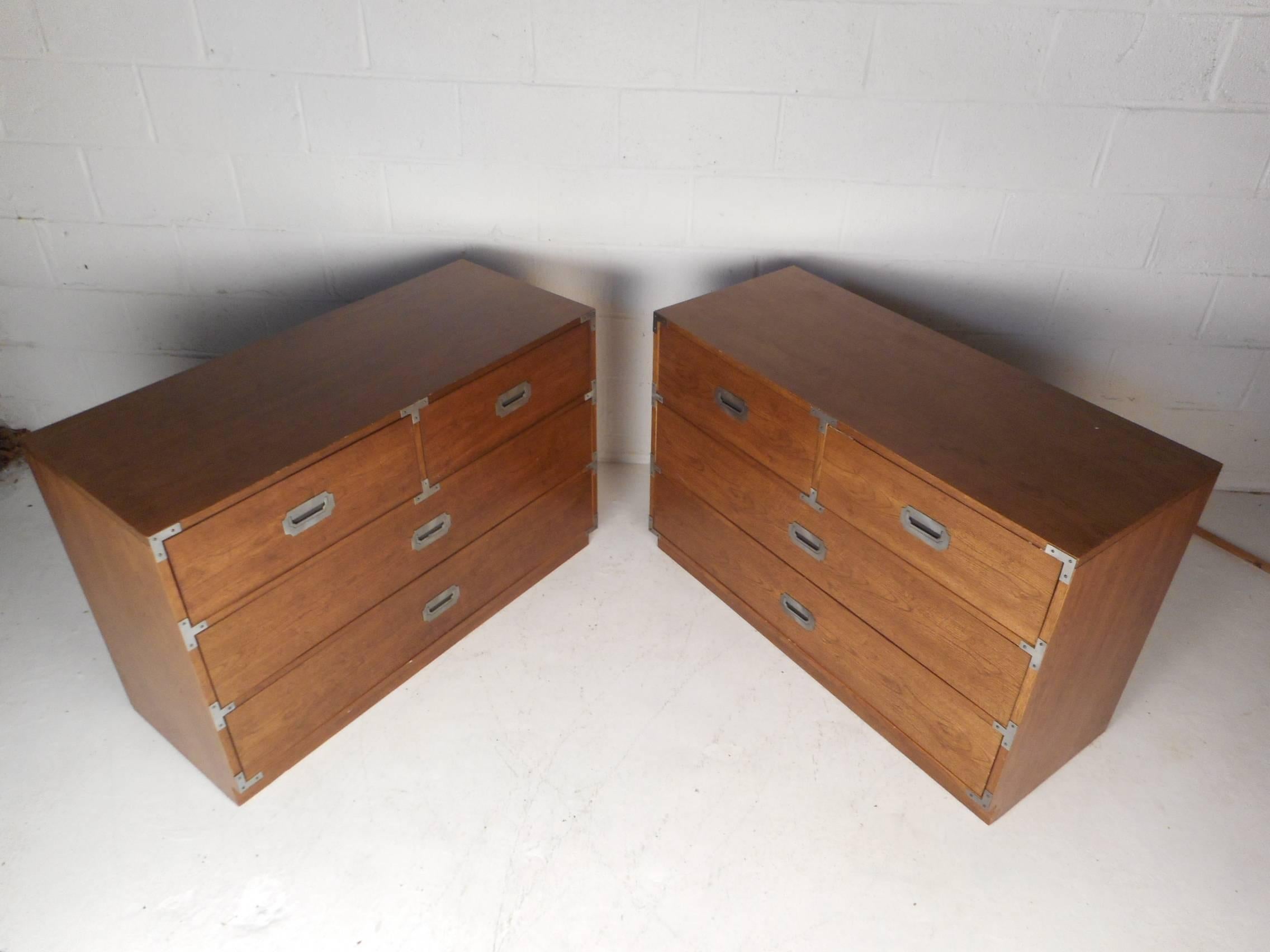 This amazing pair of midcentury style campaign chests feature four drawers on each with unique metal pulls. These well made chests offer plenty of room for storage within a compact design. This stylish pair have beautiful wood grain and additional