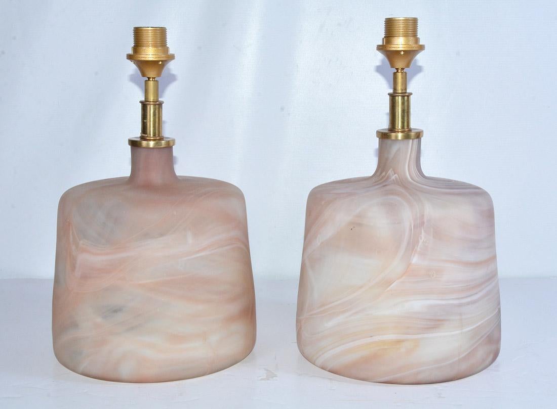 The pair of contemporary one of a kind Murano style glass lamps have marbleized swirls with mat finish. The designs are not identical. The fixtures are made for European shades. We can change out for you. Cord switch.