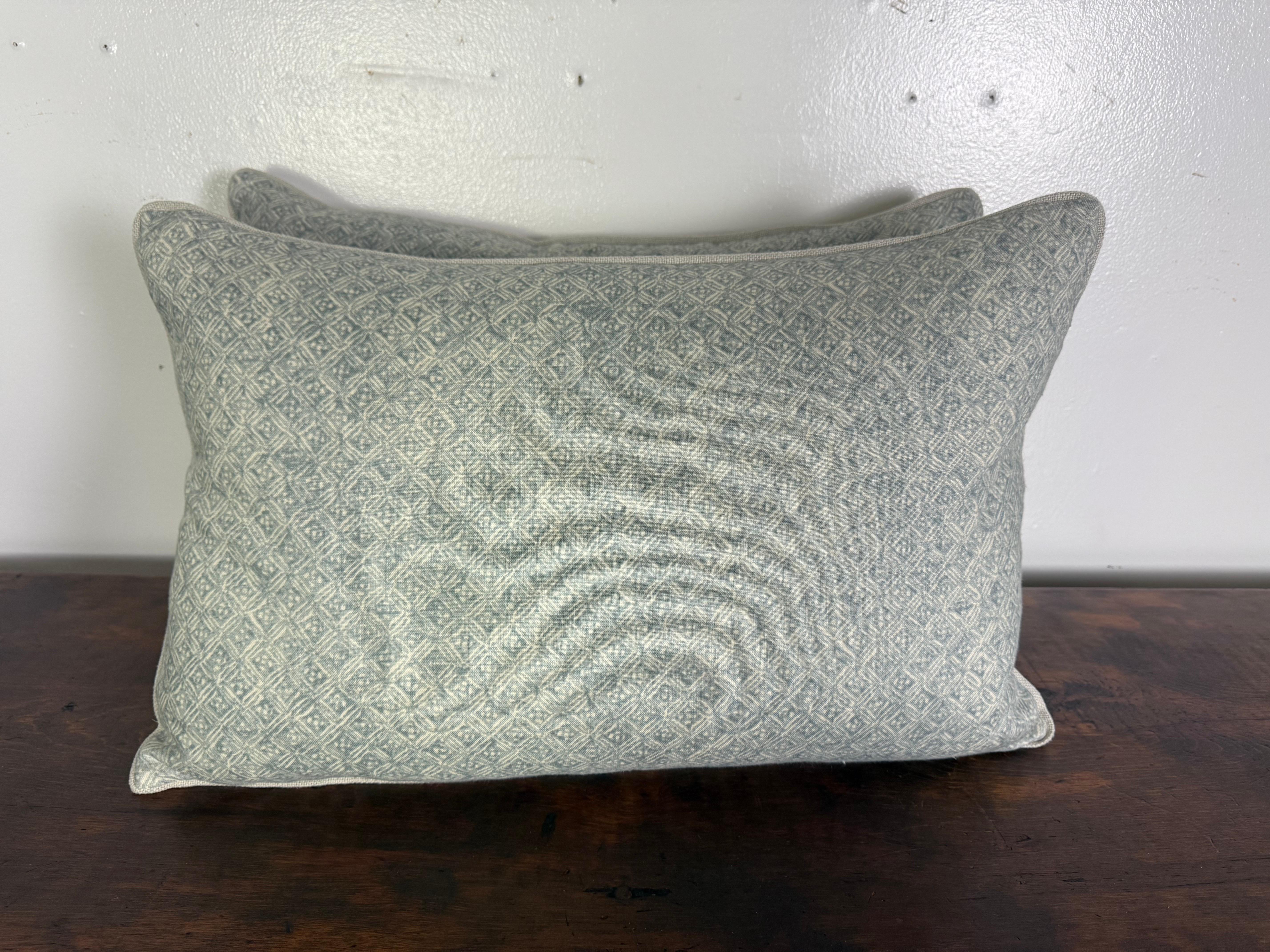 This pair of contemporary accent pillows features a subtle, diamond-patterned print in soft, muted tones on the front, lending a refined yet relaxed aesthetic. The fabric has a lightly weathered, artisanal look that adds texture and depth without