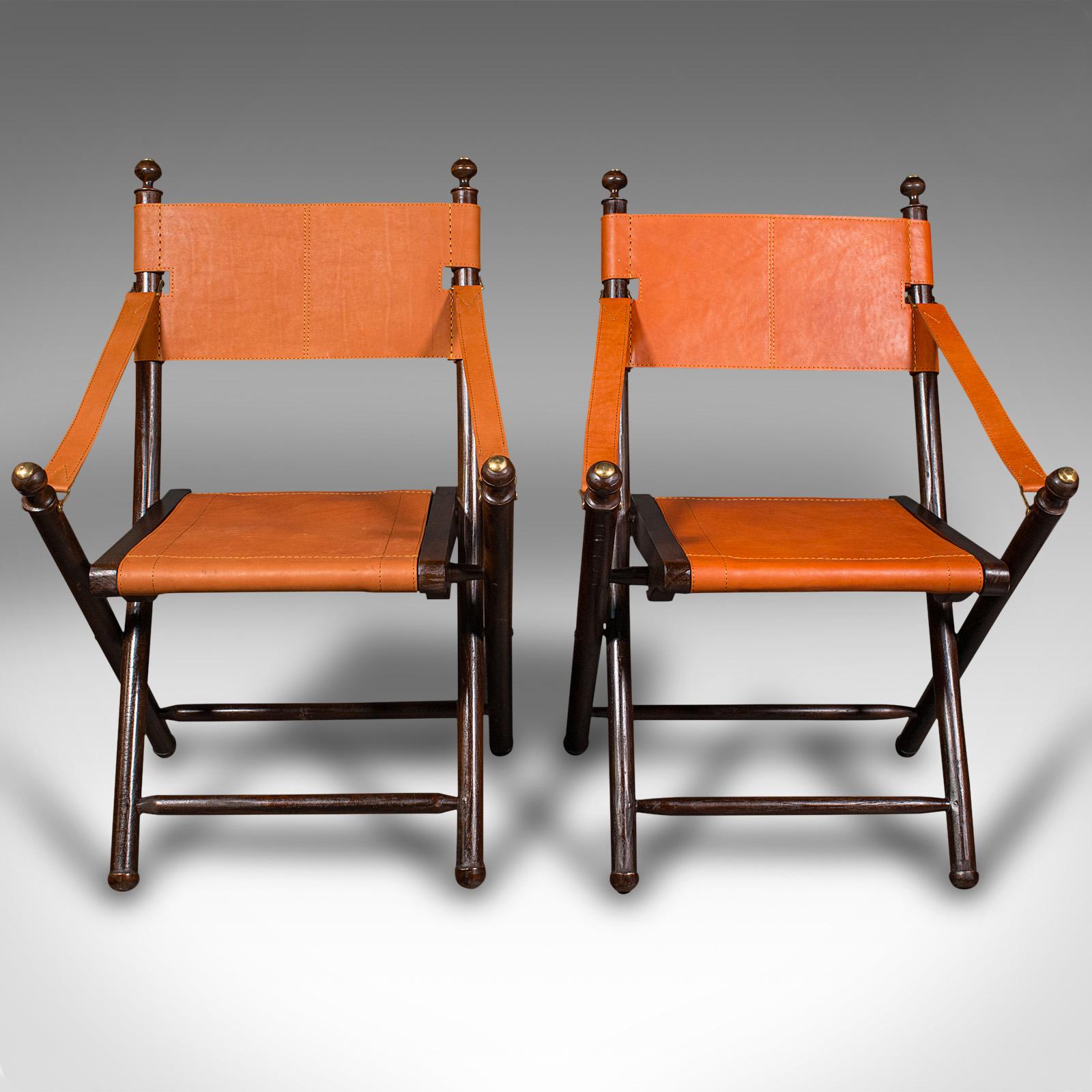 
This is a pair of contemporary veranda chairs. An English, colonial style pine and leather folding orangery or garden seat.

Highly distinctive chairs in folding director style
Presented in very good order throughout
Deep chestnut hues to the
