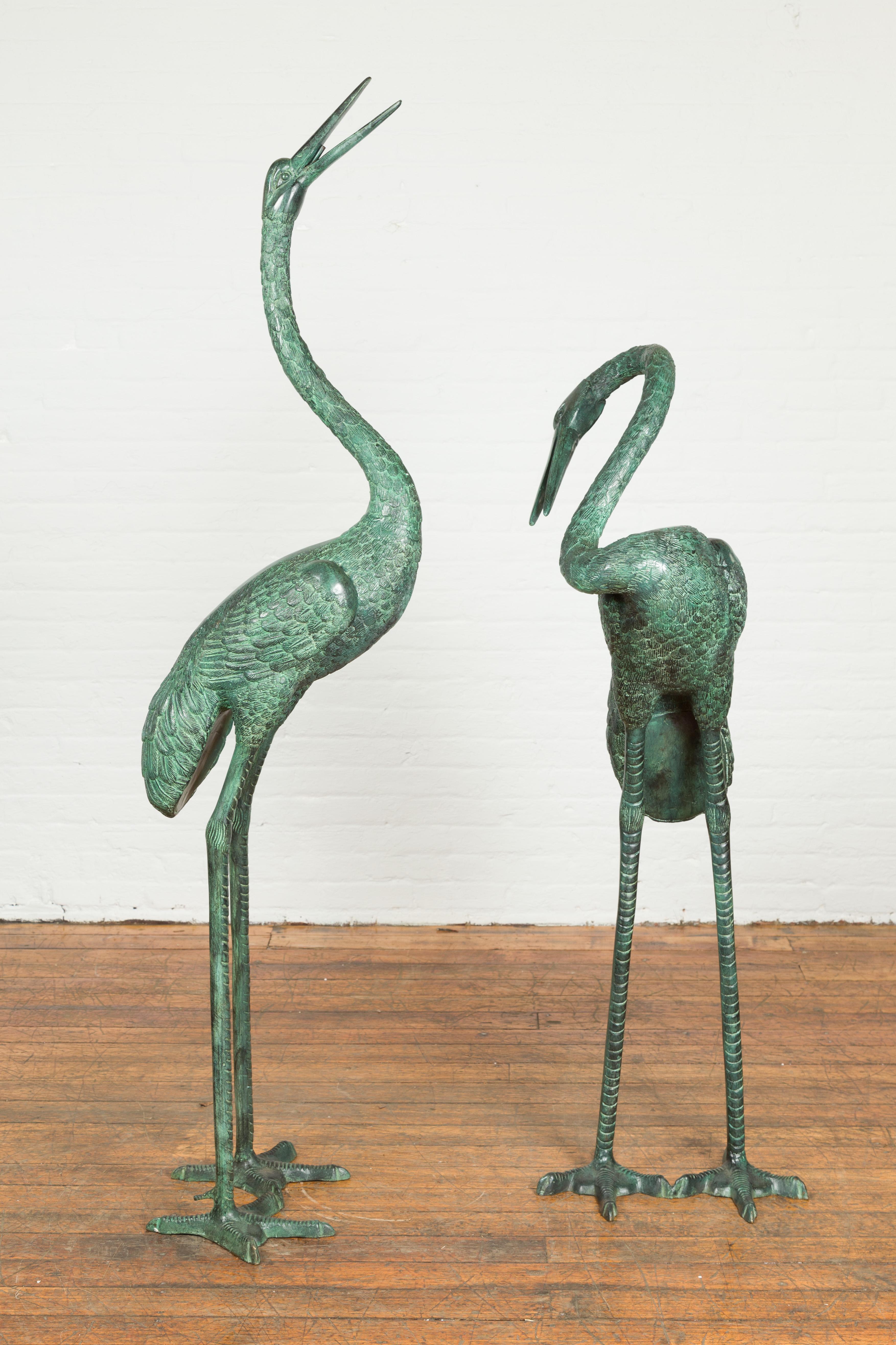 A pair of custom made lost wax cast bronze crane sculptures with verdigris patina, tubed as fountains. Created with the traditional technique of the lost-wax (à la cire perdue) that allows a great precision and finesse in the details, this sculpted