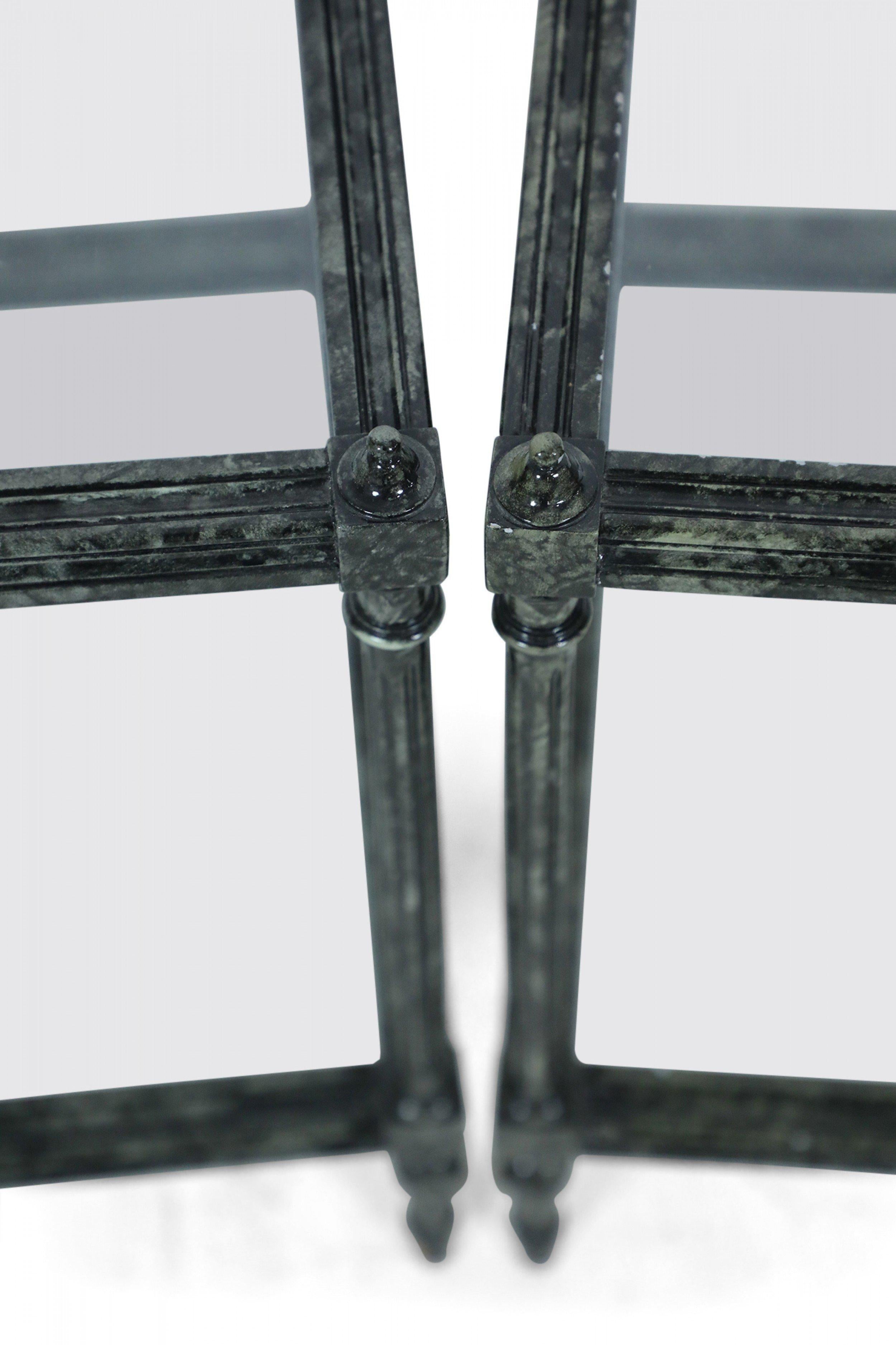 Paire de tables d'appoint contemporaines en bois peint en faux métal, avec des plateaux en verre et une tablette inférieure en verre, soutenues par des pieds en colonne cannelés surmontés de petits fleurons. (Prix par paire).
      