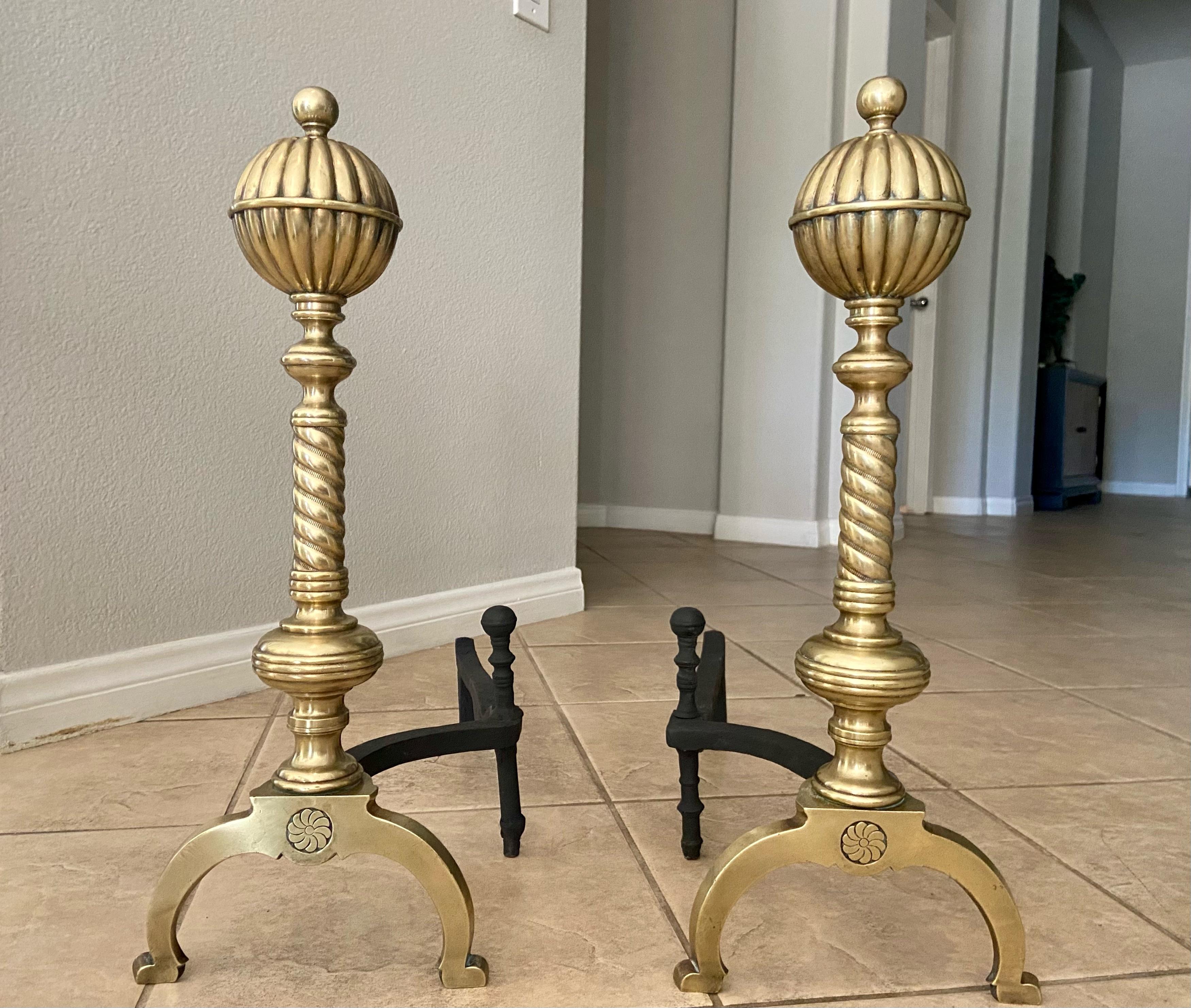 Pair of 19th century brass baluster shaped andirons with ball and pinwheel motif . A unique silhouette that can blend with both traditional and eclectic interiors.