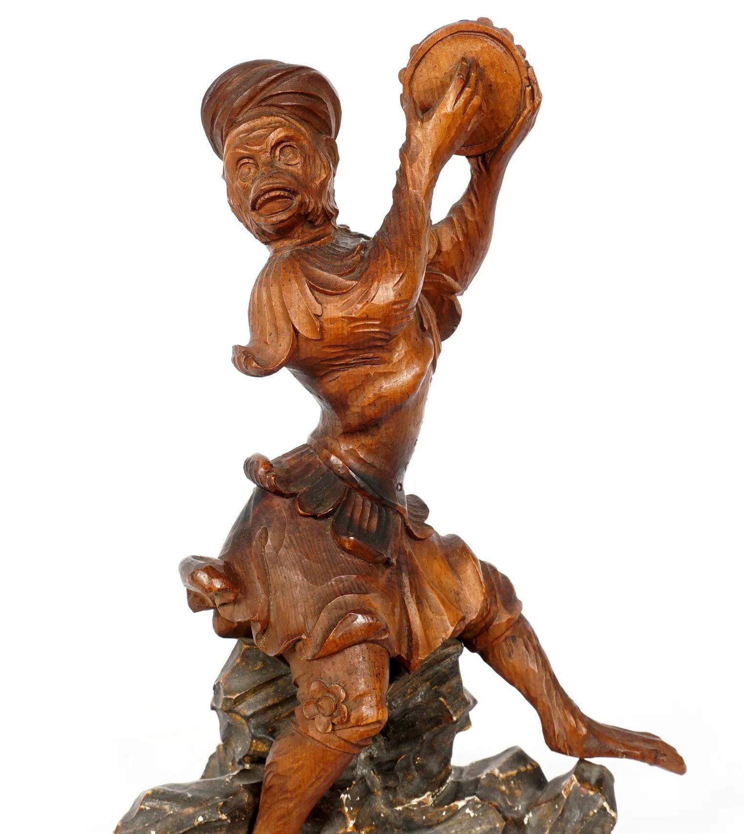 Mirror image pair of naturalistically carved figures of a seated monkey's wearing a carved giltwood cloak and turban, perched on a rocky plinth, with his hand out holding a tambourine. Amazing attention to detail and fine treatment of hair, eyes and