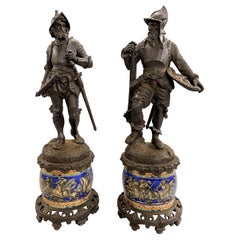 Paire de statues de soldats en fonte continentale montées sur des socles en majolique