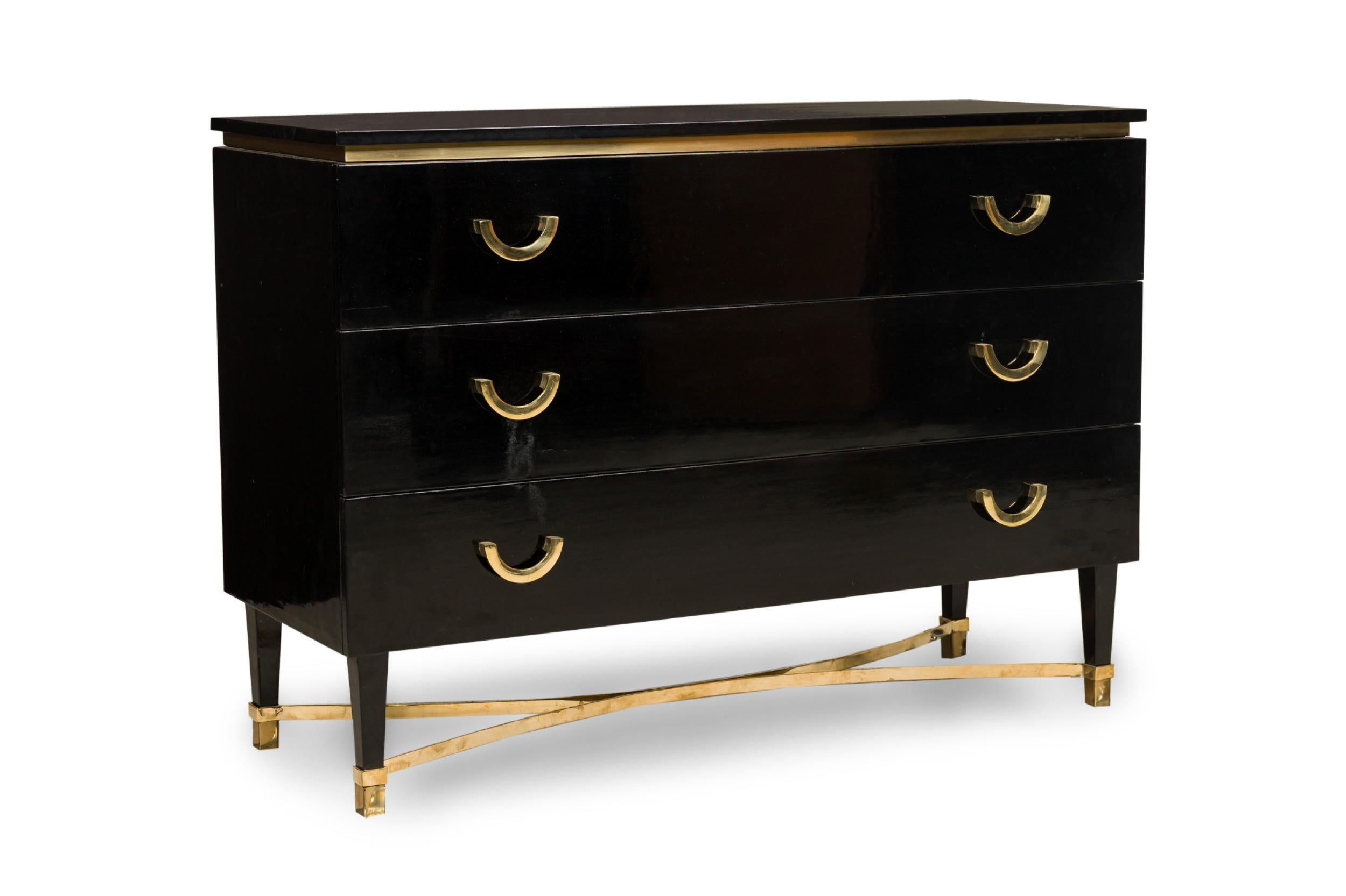 PAIR of Mid-Century Continental black lacquered rectangular wood dressers featuring a waisted top with bronze banding, 3 pullout drawers with 2 columns of bronze demilune pulls, resting on 4 tapered legs with bronze sabots, anchored by a concave
