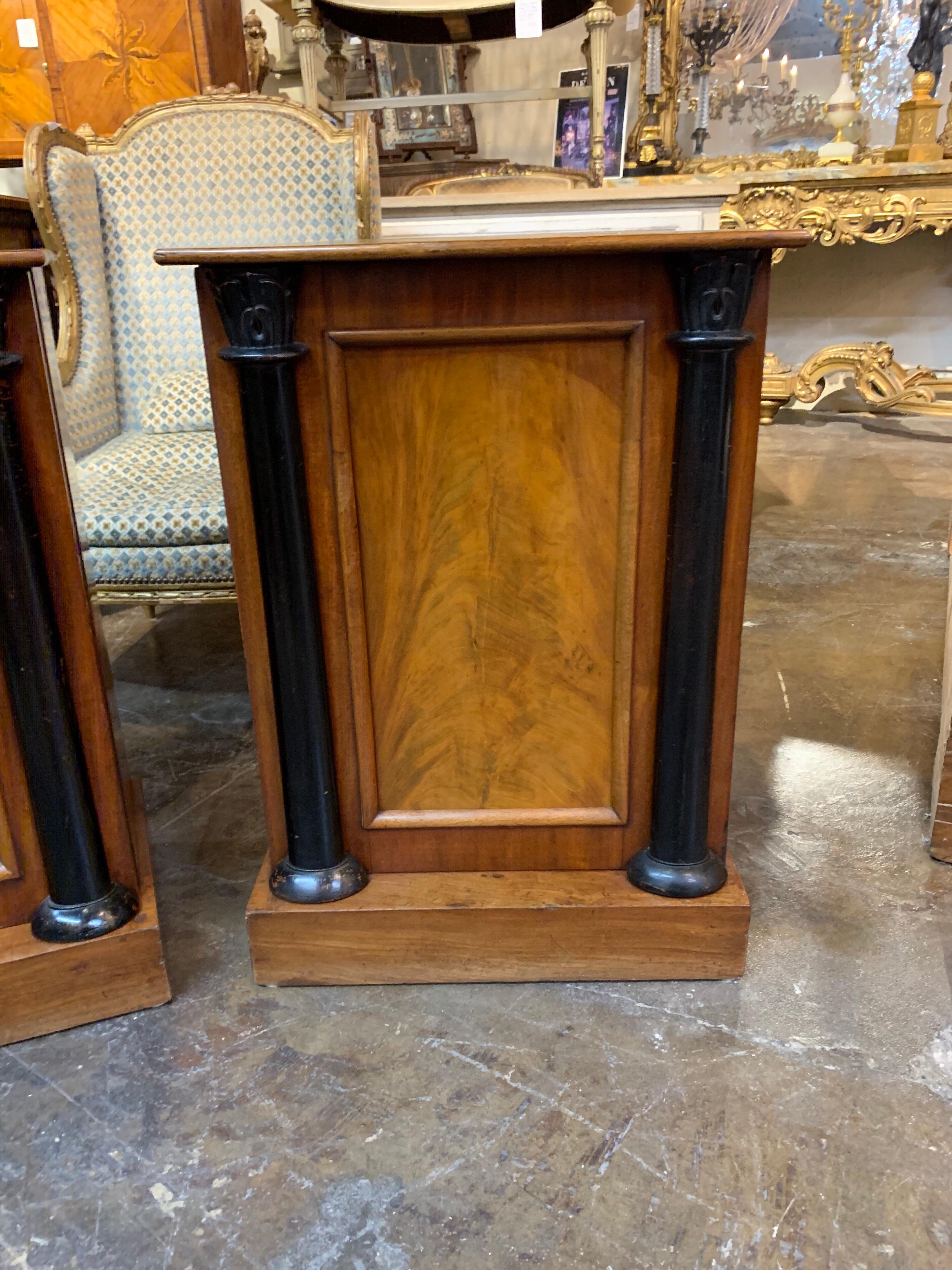 Handsome pair of Continental Empire style walnut and ebonized side tables. These tables have a very fine finish and nice storage as well. Quite elegant for a fine home!