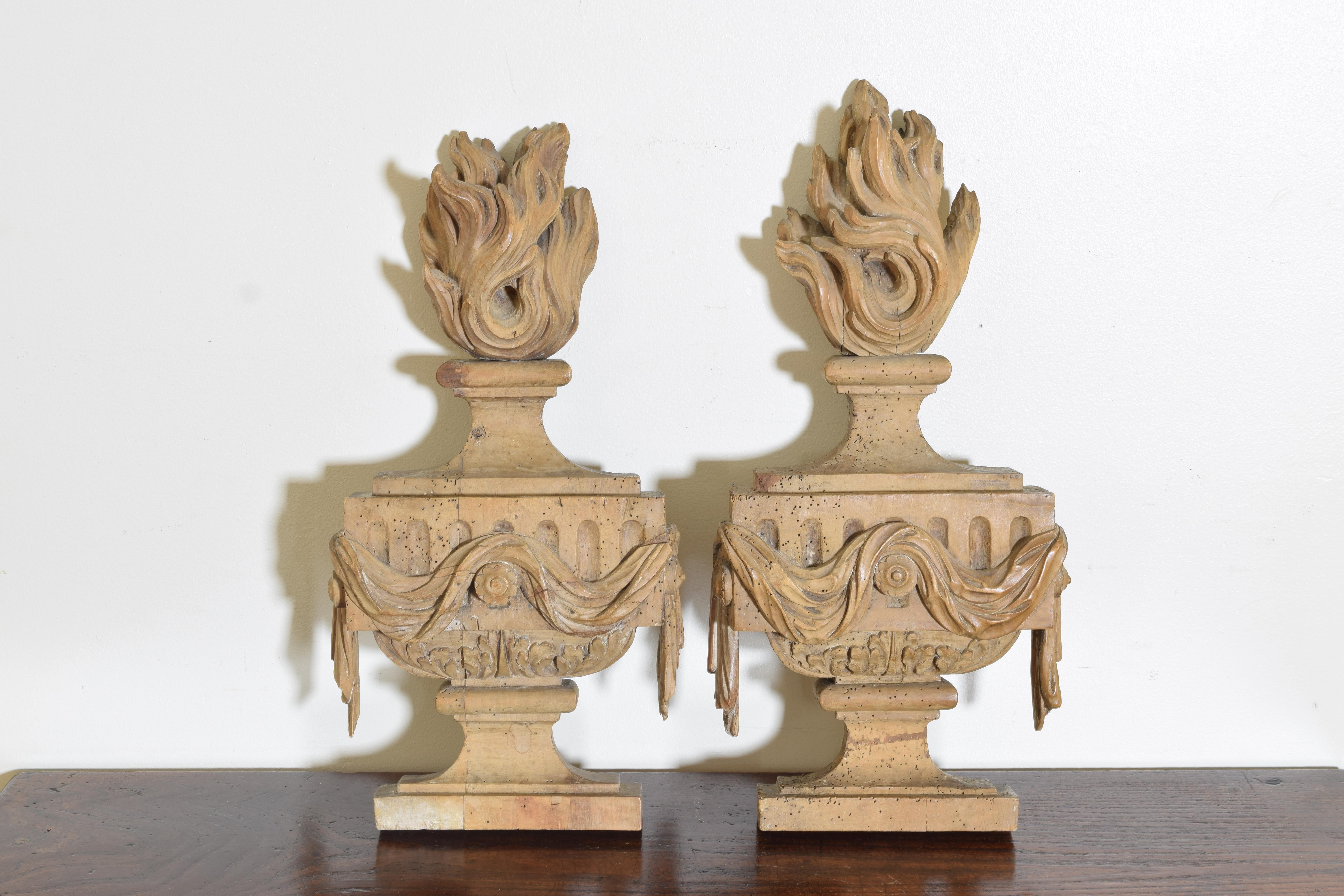 Expertly carved with urns emitting flames from their tops and draped in fabric swags, excellent as lamp bases