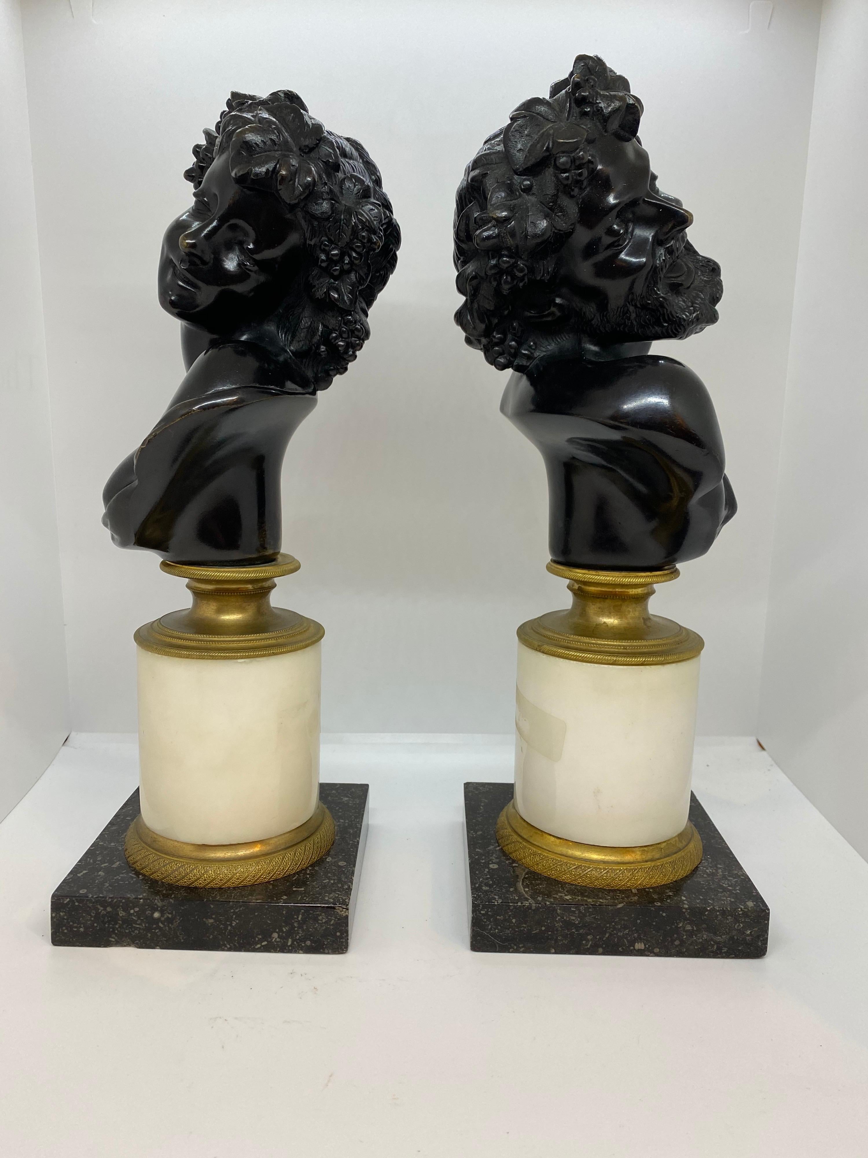 Pair of continental patinated bronze busts of Bacchus and Ariadne, busts are supported on blanc marble columns mounted by engine turned gilt bronze and square bases.