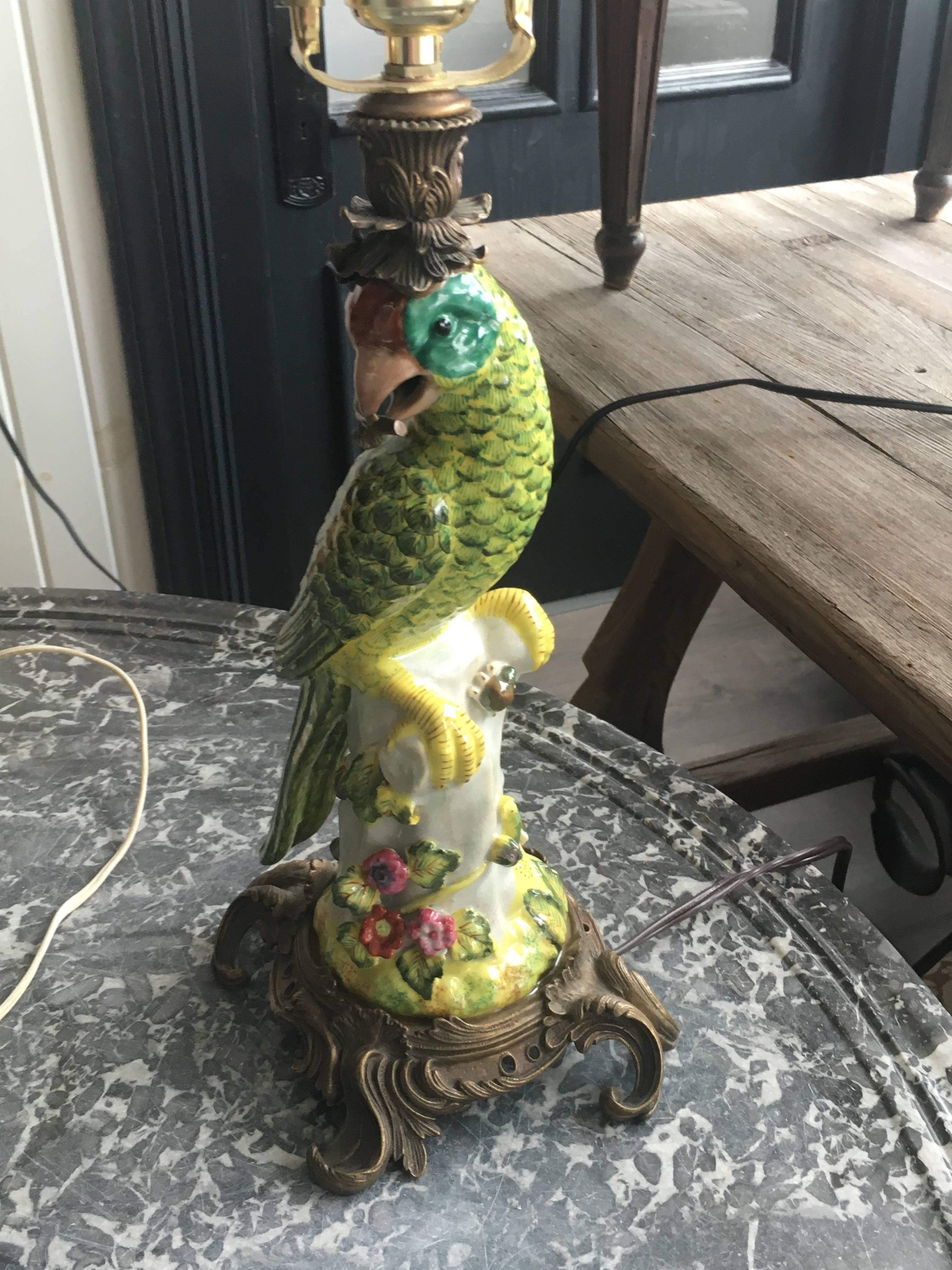 A pair of Hollywood Regency Continental porcelain figural lamps 
20th century 
Each in the form of a perched parrot, set in Rococo gilt metal mounts. 
Height overall 25 1/2 inches.