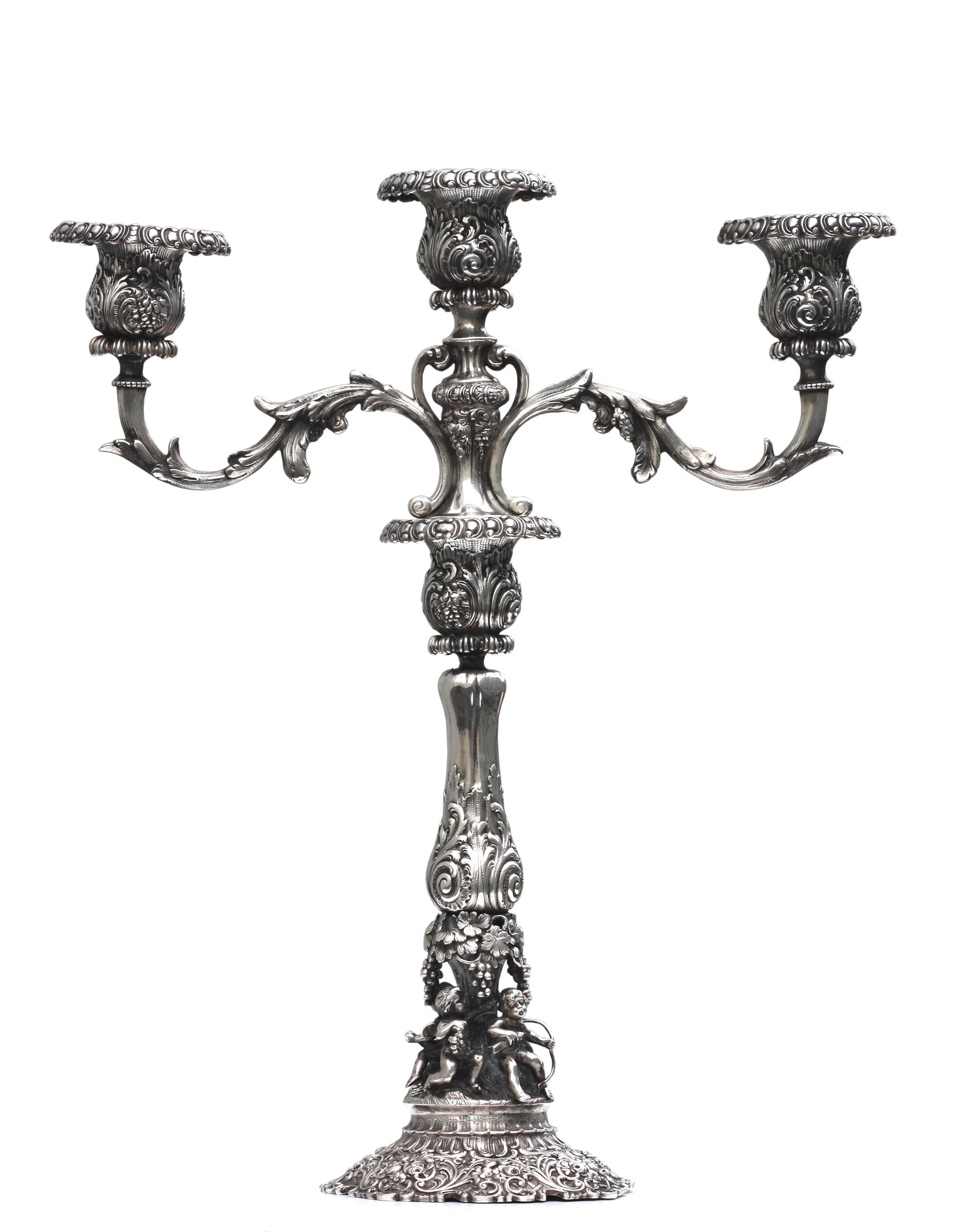 
Pair of Continental Renaissance Style Silver Three-Light Candelabra
Late 19th Century. Each shaft marked 800, with a crown and two further indistinct marks. The lower part with a flared leaf chased shaft and nozzle, above an open section with four
