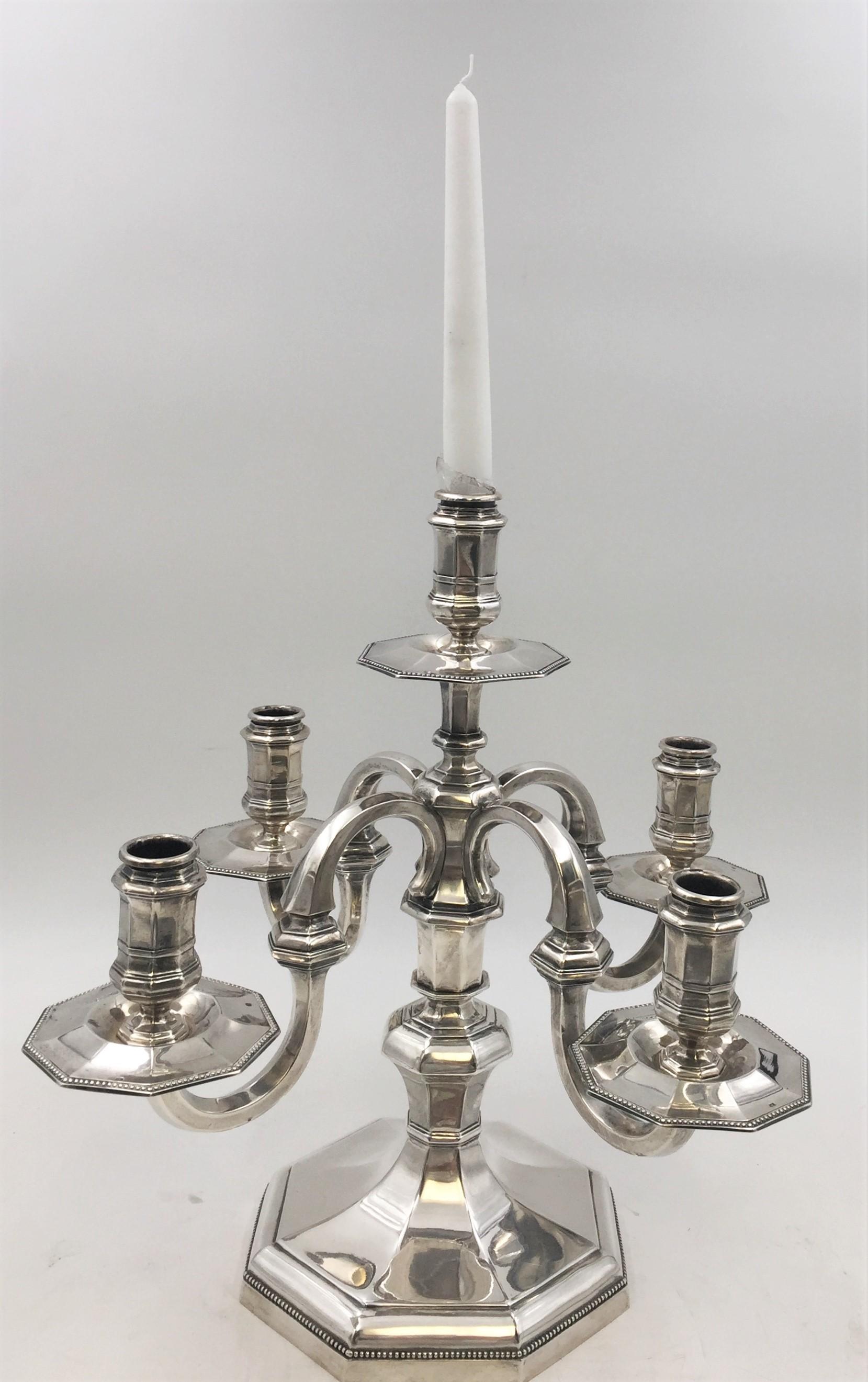 A beautiful pair of continental silver five light candelabras, 20th century. Designed with a smooth multi faceted surface and detailed beading around the base and bobéches. Weighing 92 troy ounces, measuring 14.5 inches in height and 15.8 inches