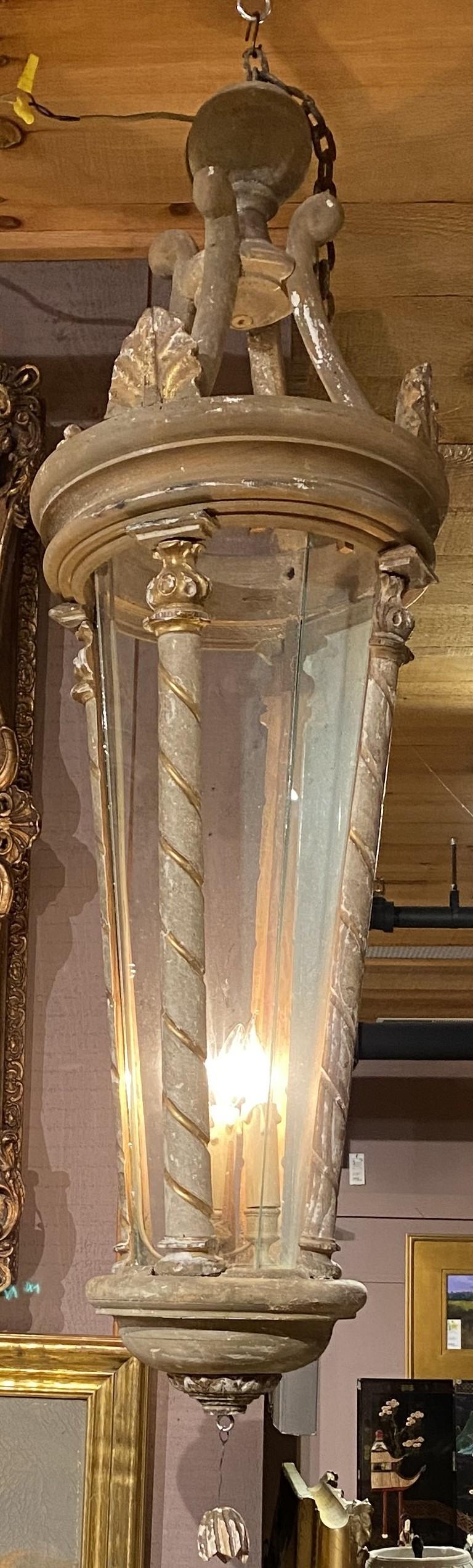 A fine pair of round tapered three light wooden painted hall lanterns / fixtures with globe finials, scrolled crowns, acanthus apliques, gilt spiral half columns, glass panels, probably French or Italian in origin, dating to the 20th century. Good