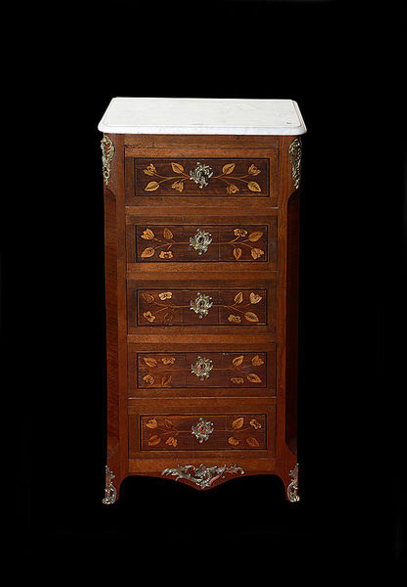 A pair of late 19th century Continental walnut and rosewood and satinwood marquetry chests of five drawers, each white a marble top.

The whole with decorative metal mounts and escutcheons.
Each drawer front inlaid in satinwood with trailing flowers