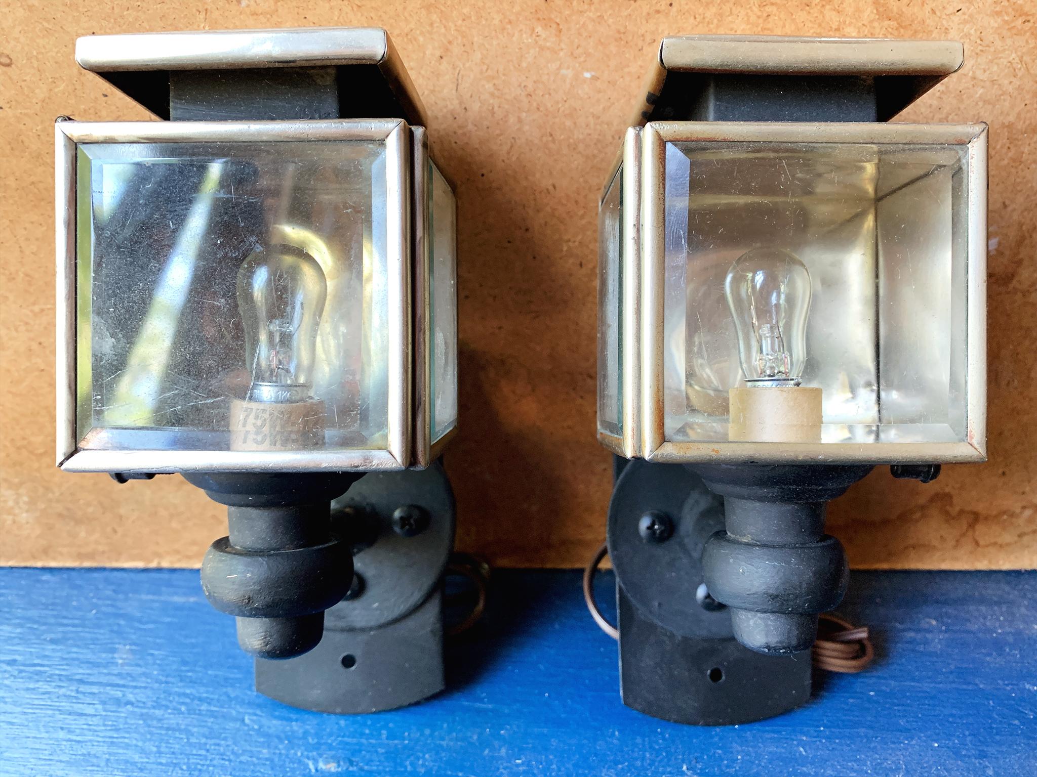 These two charming sconces are converted lights from a 1910s Studebaker automobile. They have metal frames with beveled glass covers and black-painted metal armature. The back plates are new, as well as the wiring.

Dimensions:
3.5 in. width
3.5