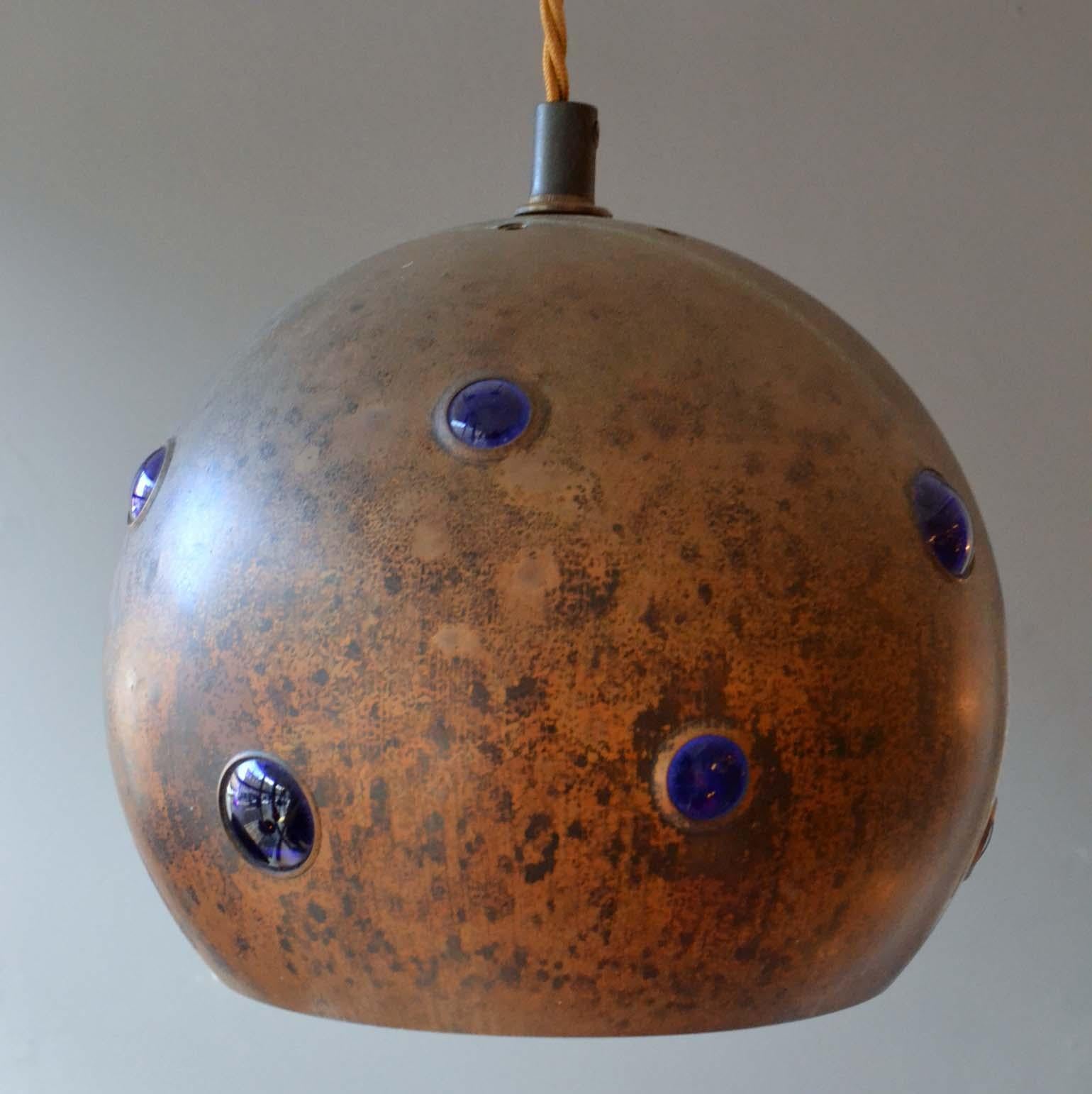 Mid-Century Modern blue glass & patinated copper pendant lamps. They are unique in execution. Deep blue glass is blown into oxidized copper spherical shells and glass creates bubbles through the holes. The lamps can be adjusted to alternating