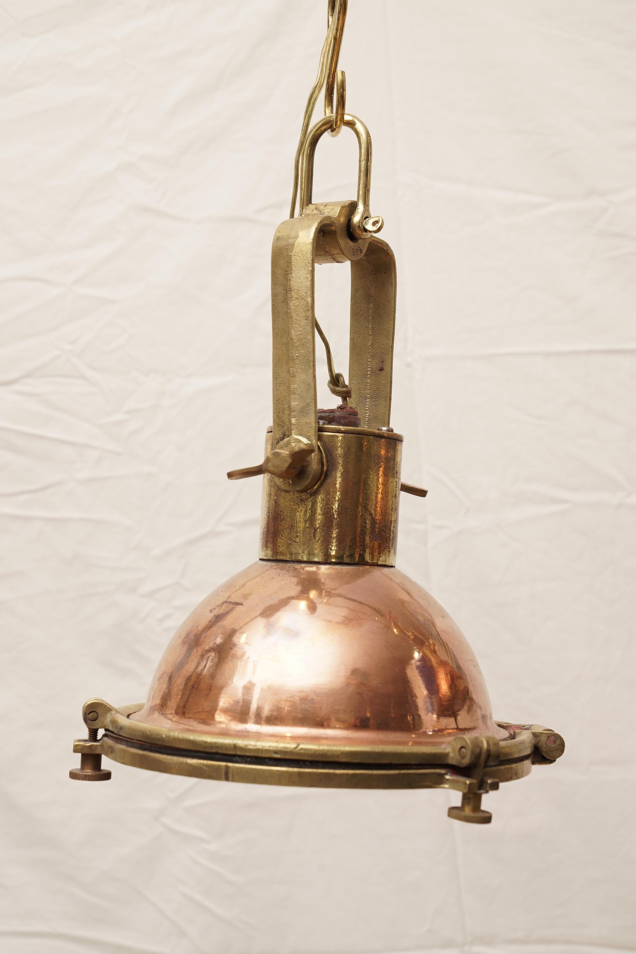 A pair of copper and brass deck lights used on ship's to load and unload cargo at night. Hinged face plate for changing the light bulb and reflective paint inside which helped to create additional light. Rewired for American use. Originally