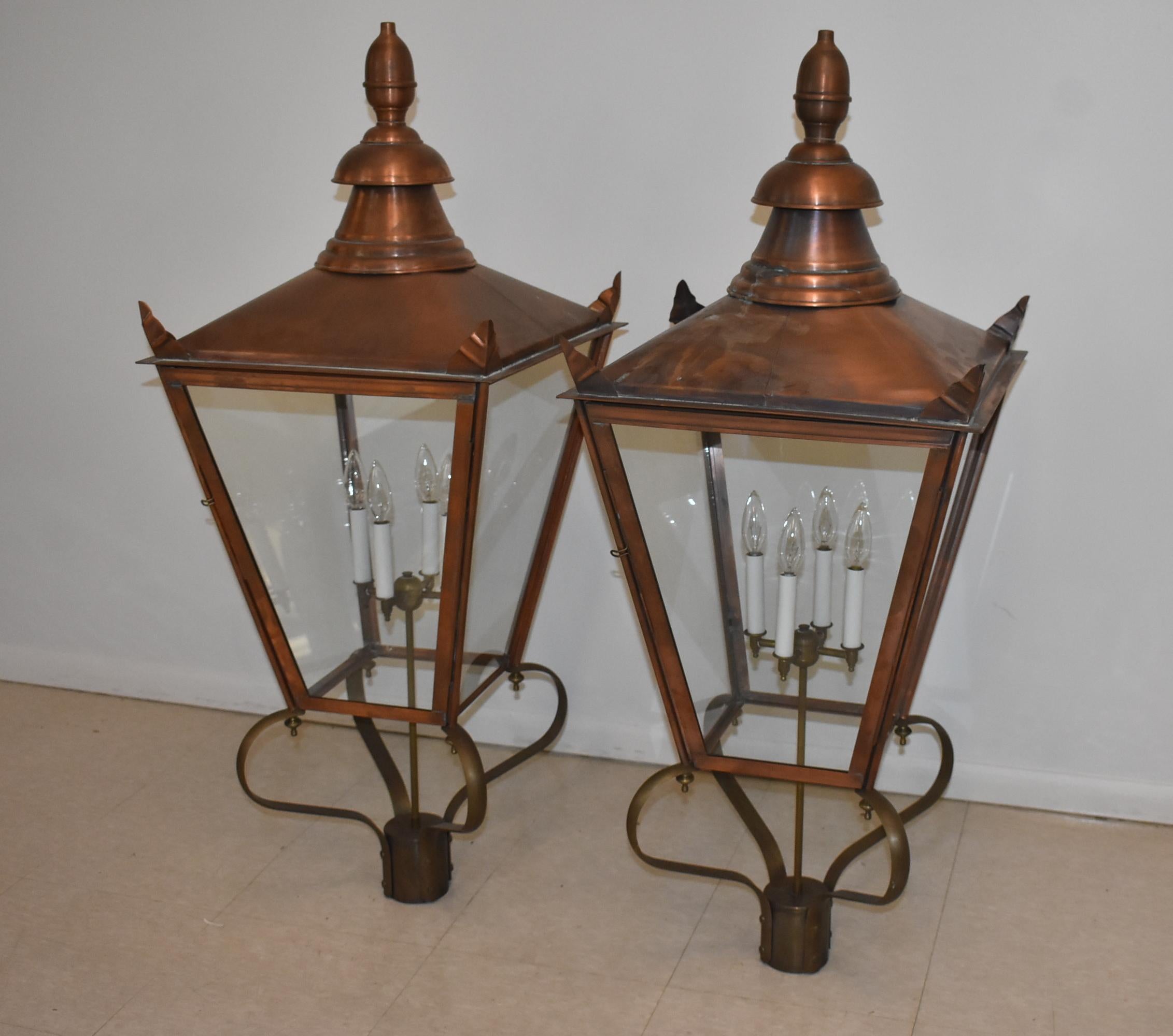 Pair of copper and brass oversize exterior Williamsburg lanterns. Four candelabra lights. Door panel opens for access. Measures: 2 7/8