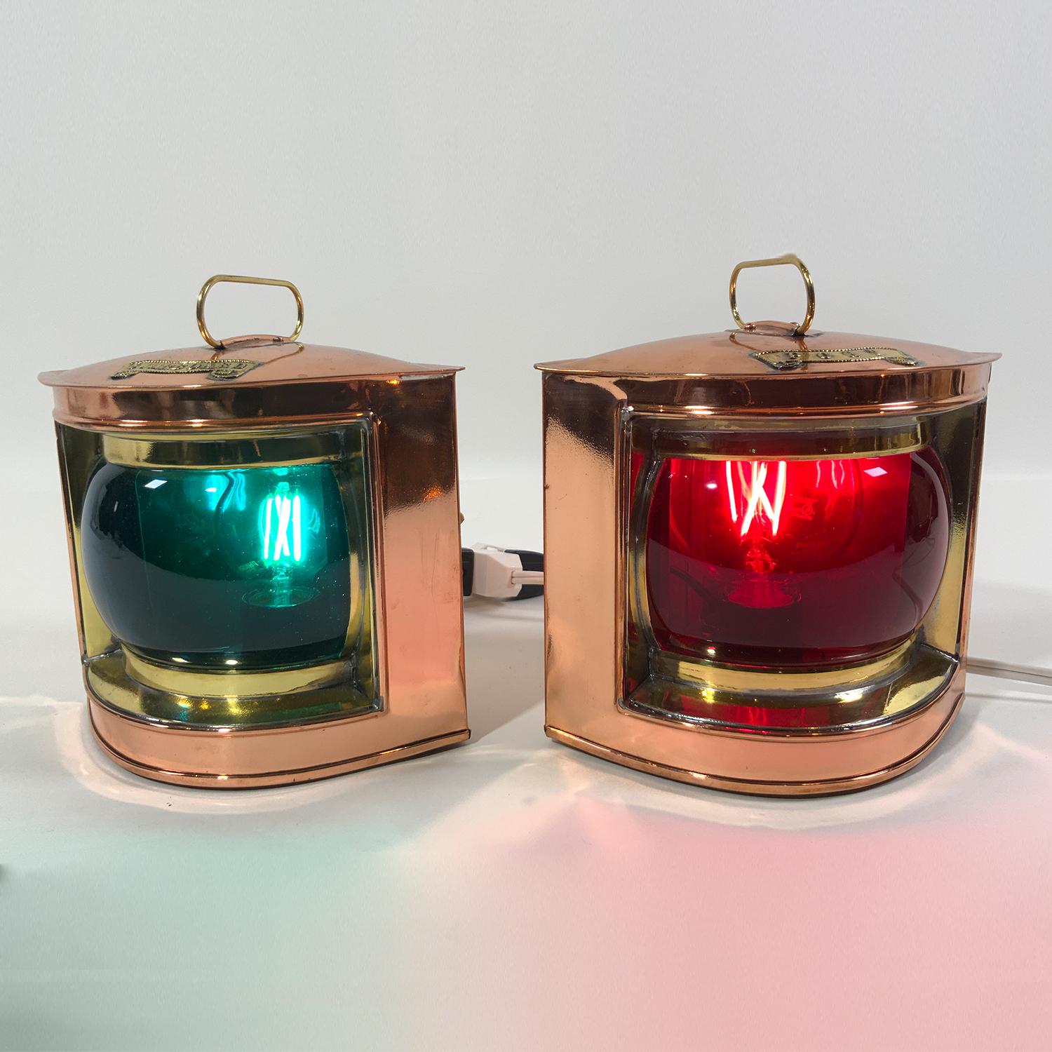 Exceptional pair of highly polished port and starboard boat lanterns with copper cases and brass badges, lens barrels and carry handles. Fitted with new sockets and led bulbs for home use. Rich ruby red deep blue glass globes.