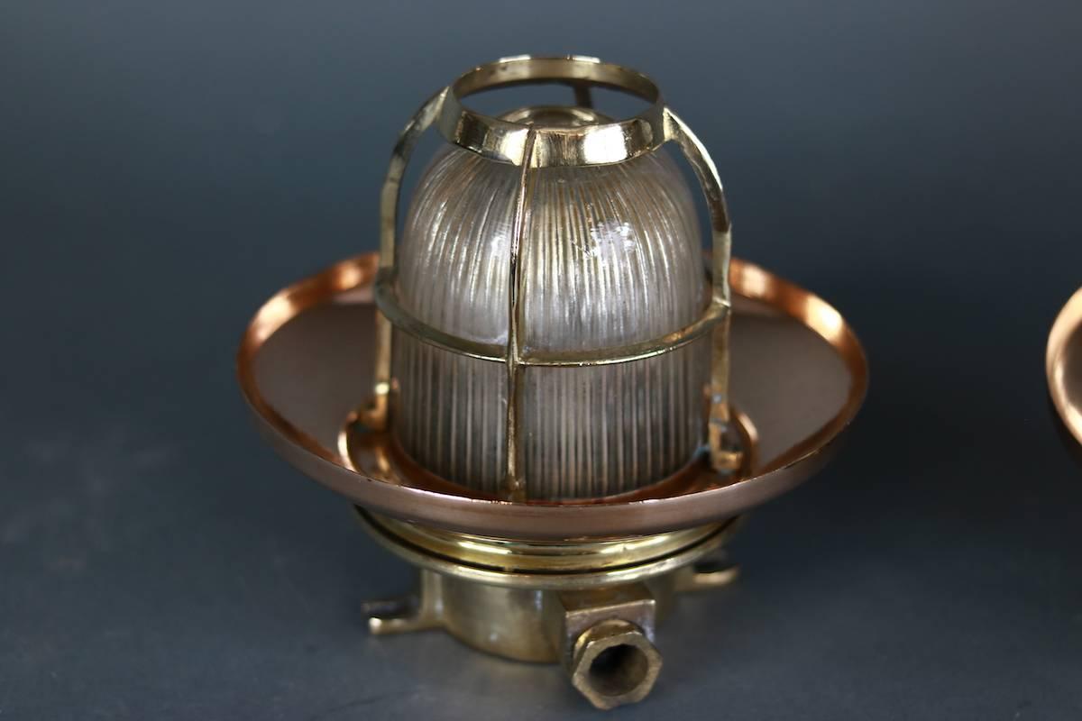 Copper and brass ship ceiling lights with explosion proof glass jars and brass protective cages. Approximate 7 inches from ceiling mount x 7 inches diameter.