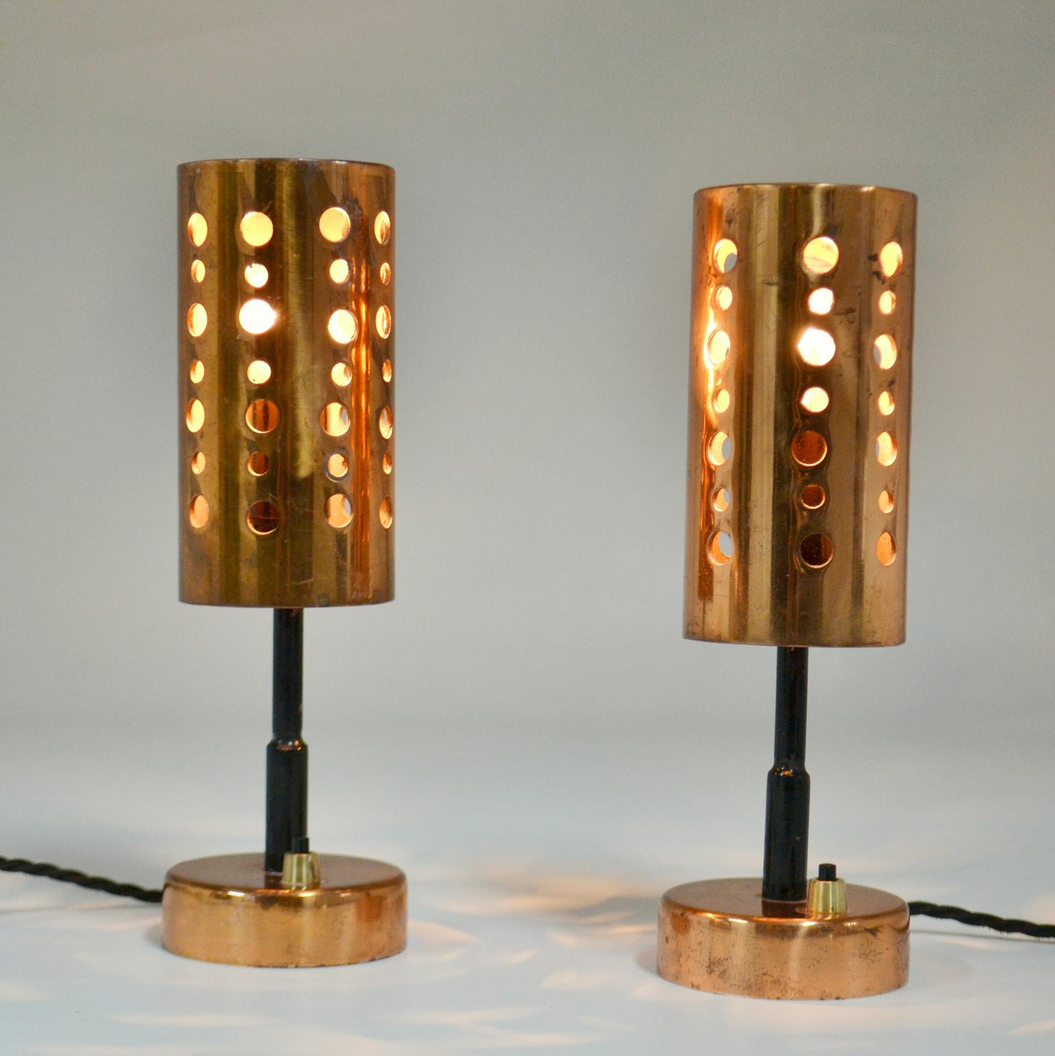 Small Mid-Century Modern copper table lamps have cylinder shape perforated shade on a black metal stem and copper feet.
Priced and sold as a set.