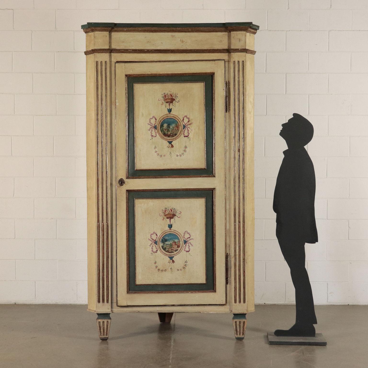 Pair of big corner cabinets with rudentate pillars that end with pyramidal truncated feet and with a two-panels door. Their have ivory and blue lacquered frames on the panels while the frames of the upper molding and on the collars of the feet are