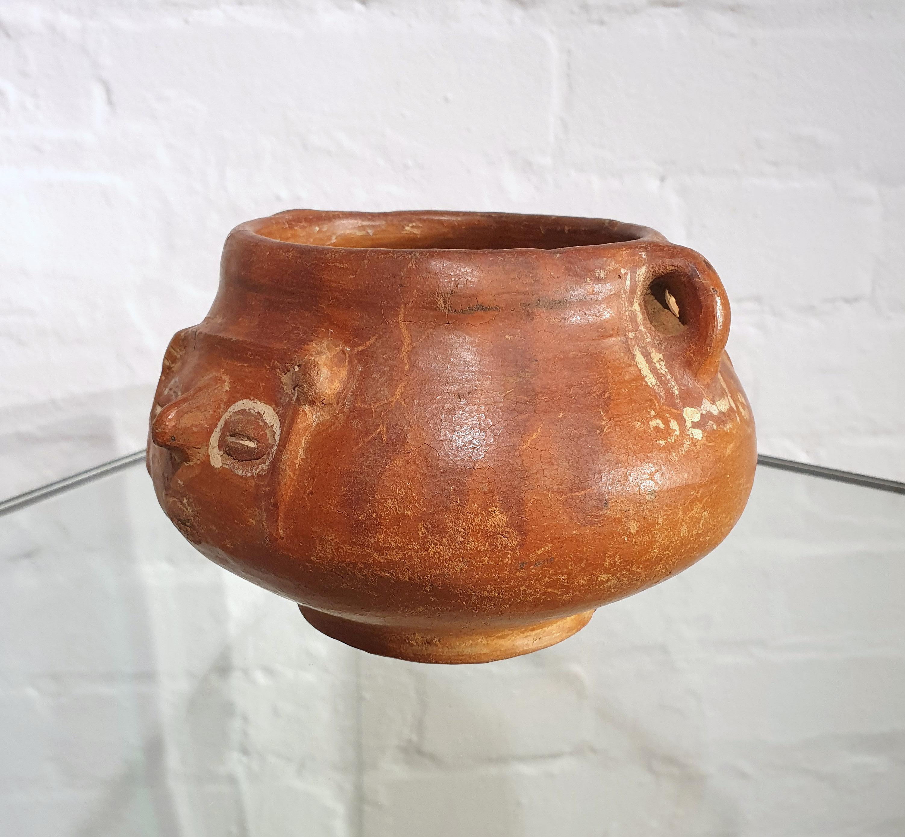 This beautiful and highly decorative pair of Costa Rican terracotta bowls are ovoid in shape and come from the Talamancan Mountains region. They are decorated stylized human faces in relief and are very similar in size. The shorter bowl measures 4