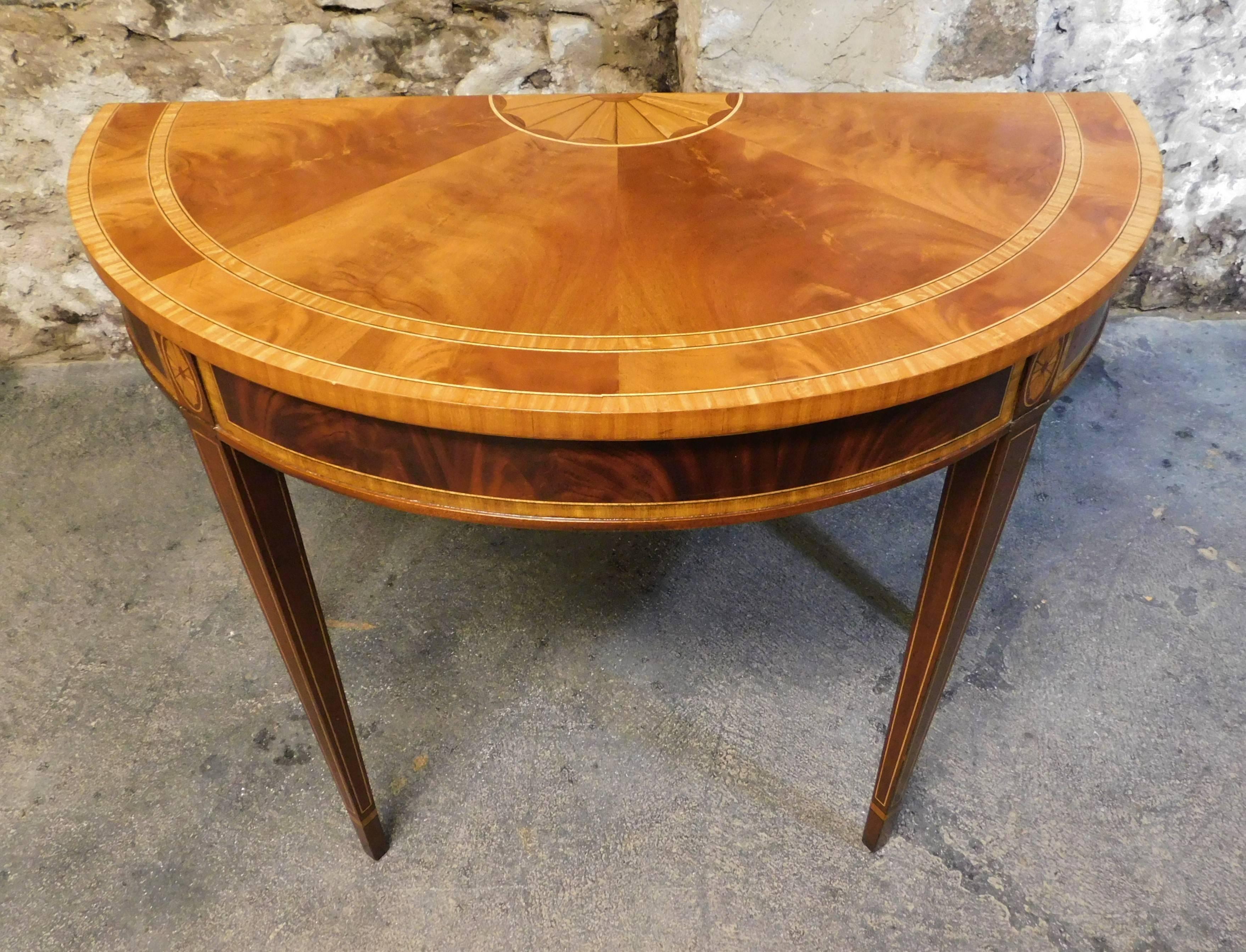 This pair of Councill Craftsman half round inlaid tables came out of the Governor General suite of the famous Royal York Hotel in Toronto. They showcase beautiful patterns done in burled walnut and satinwod veneer. These demi-lune tables are done