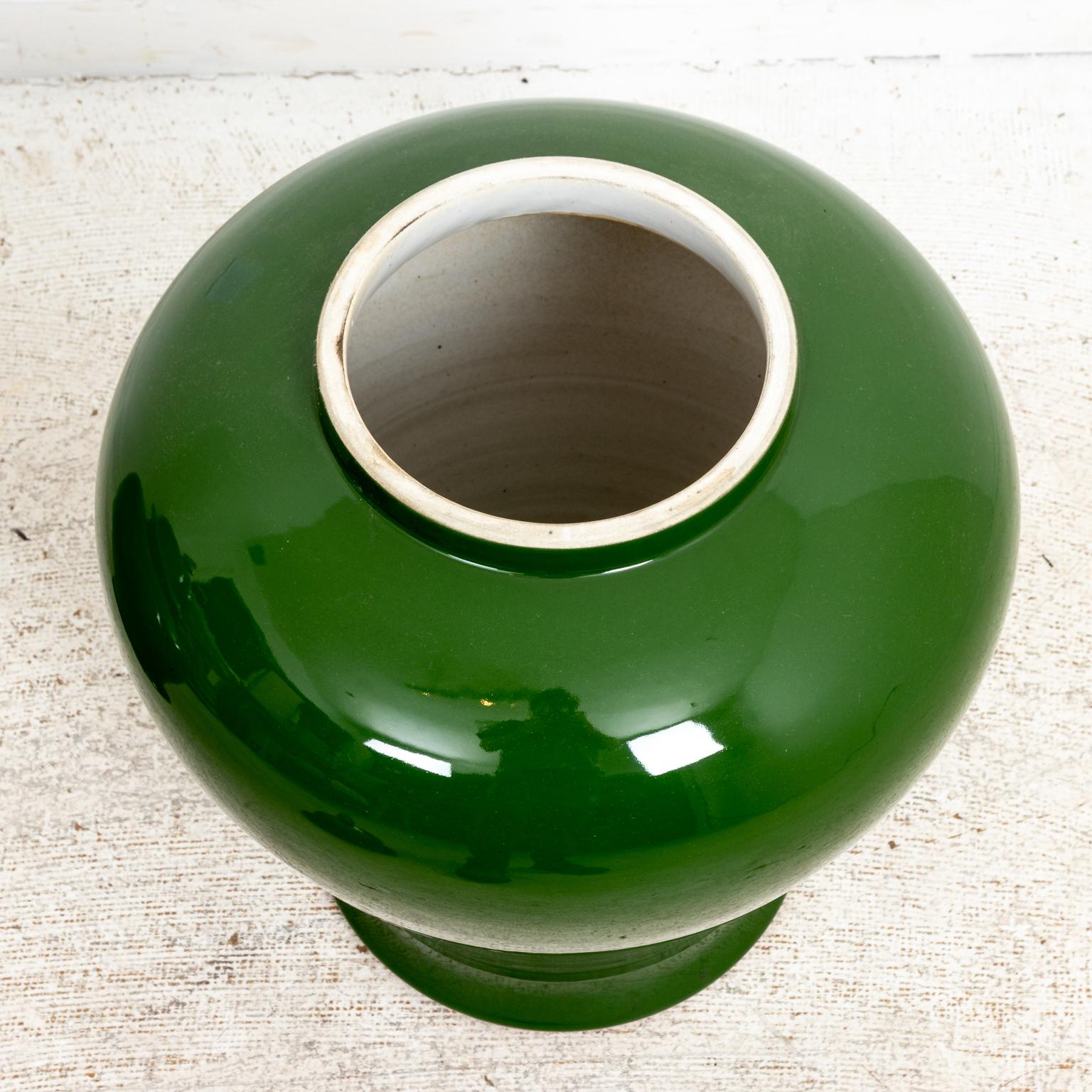 Pair of green painted covered Asian Style temple jars with lids and pointed finials. The jars are in a glazed finish. Please note of wear consistent with age including minor chips and finish loss to the glazing.