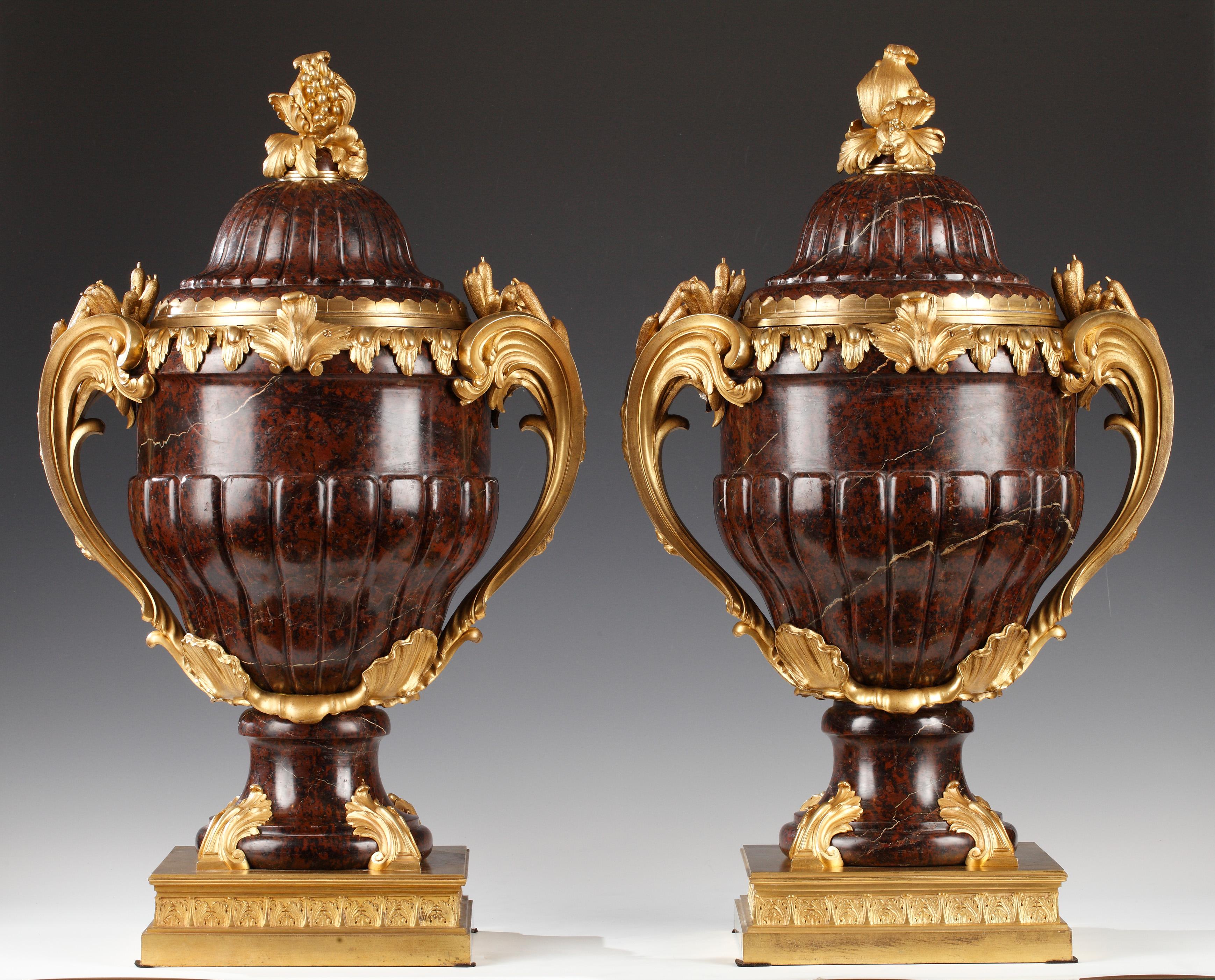 Importante paire de vases couverts de forme galbée de style Louis XV attribués à la Maison Lexcellent, avec godrons, en granit d'Assouan, bronze ciselé et doré. Le couvercle est surmonté d'une grenade feuillagée, le corps flanqué de grandes anses