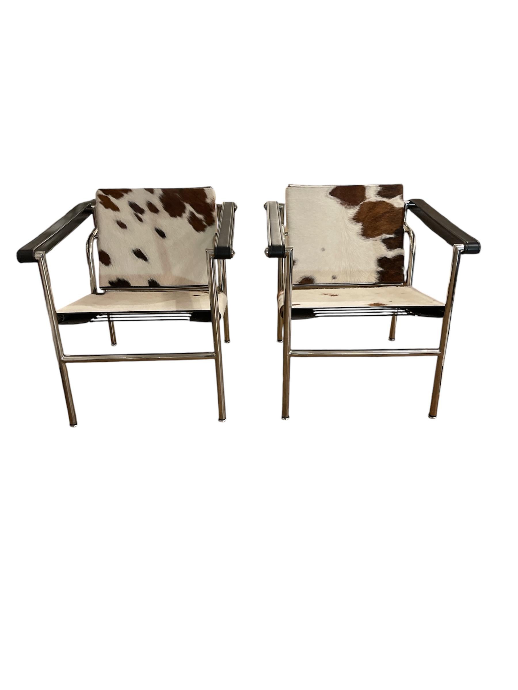 A masterpiece of modernist design, this Pair of Cowhide Armchairs with a tilting backrest is an iconic collaboration between Le Corbusier, Pierre Jeanneret, and Charlotte Perriand—three of the 20th century's most influential architects and