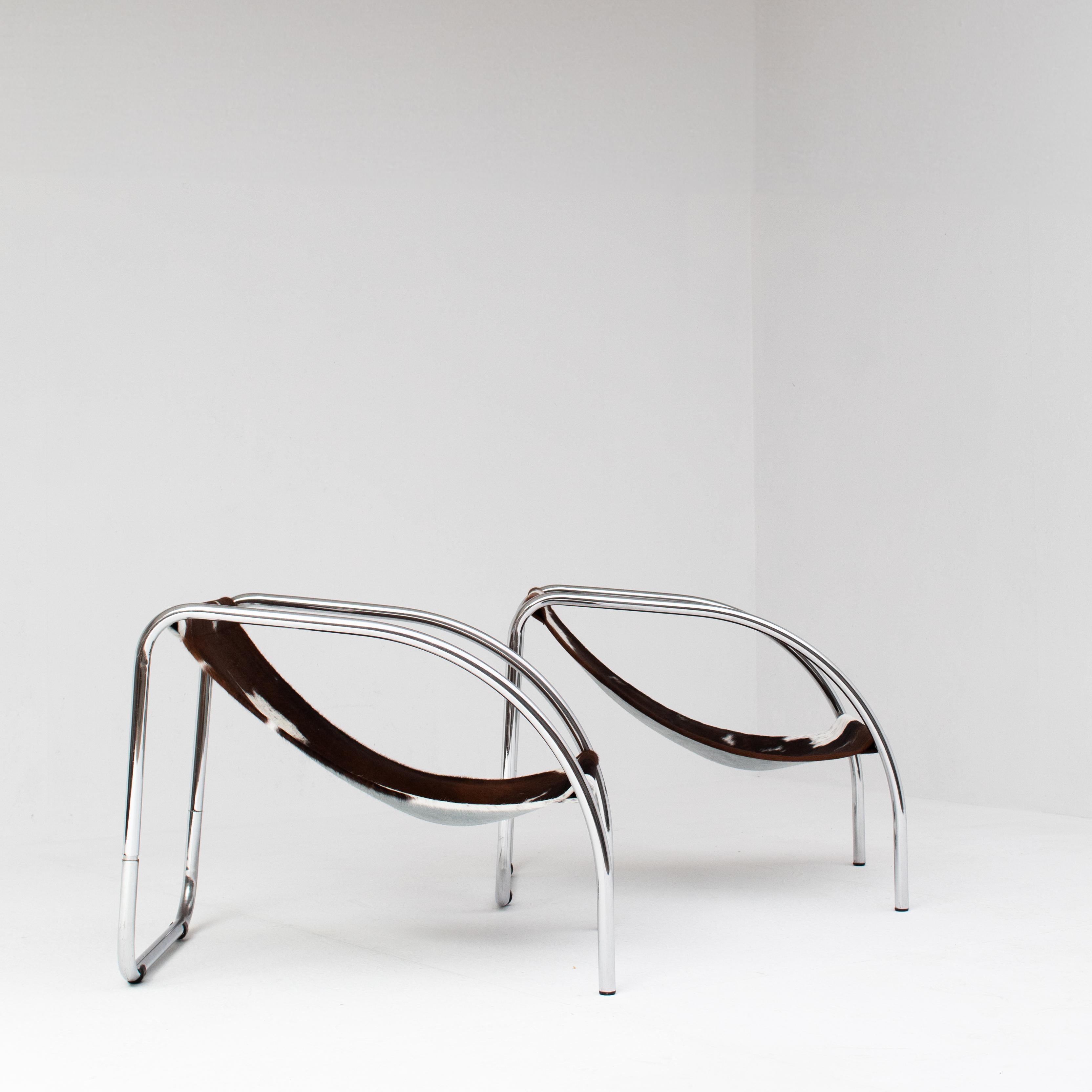 Cette paire de chaises en cuir de vache combine des lignes modernistes avec une finition brute et organique. Dotée d'une structure tubulaire chromée et nouvellement recouverte de cuir de vachette véritable, chaque chaise apporte à la fois contraste