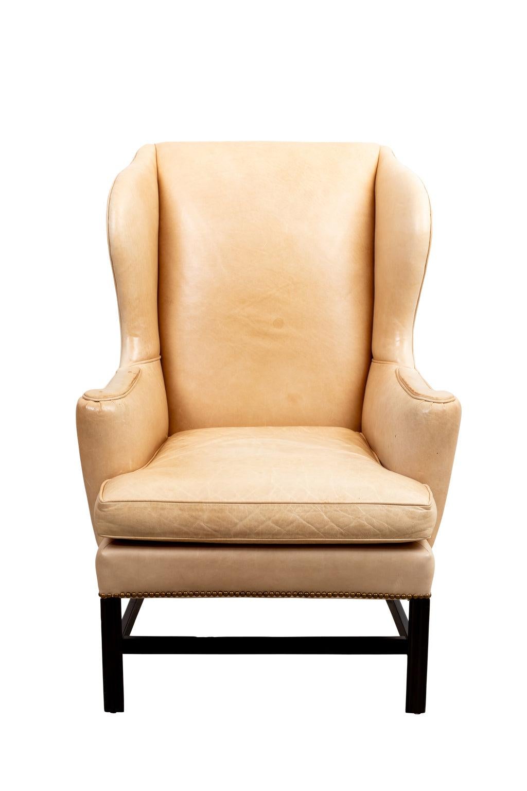 A pair of classic and traditional vintage Cowtan & Tout camel colored leather wing chairs
