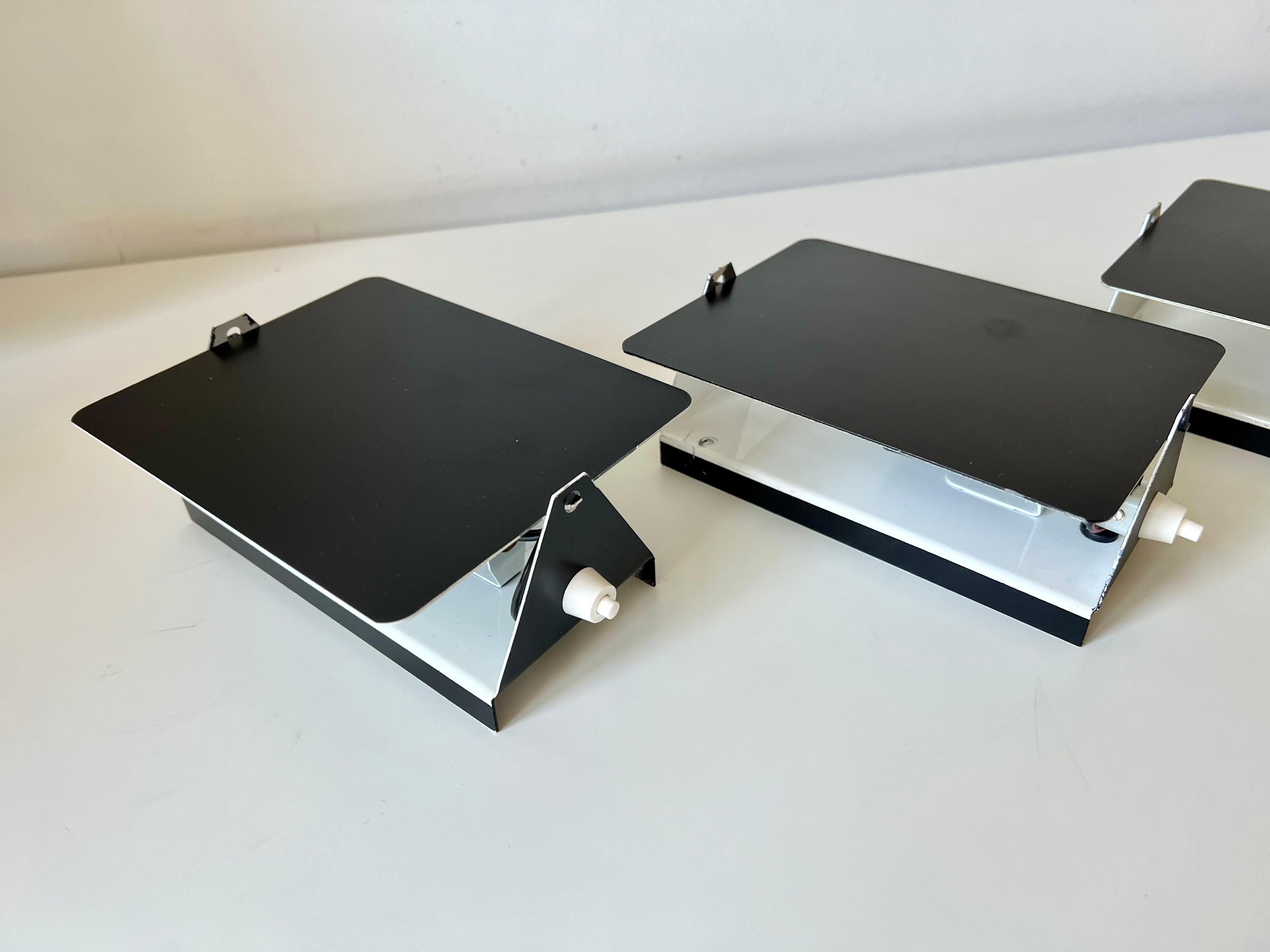 Pair of wall lights. 

Model CP1 designed by Charlotte Perriand for Steph Simon.

Sourced from the Haute Savoie region of France.

These are 1970s editions.

Metal with original paint finish. 

In very good condition, no damage or dents. Light signs