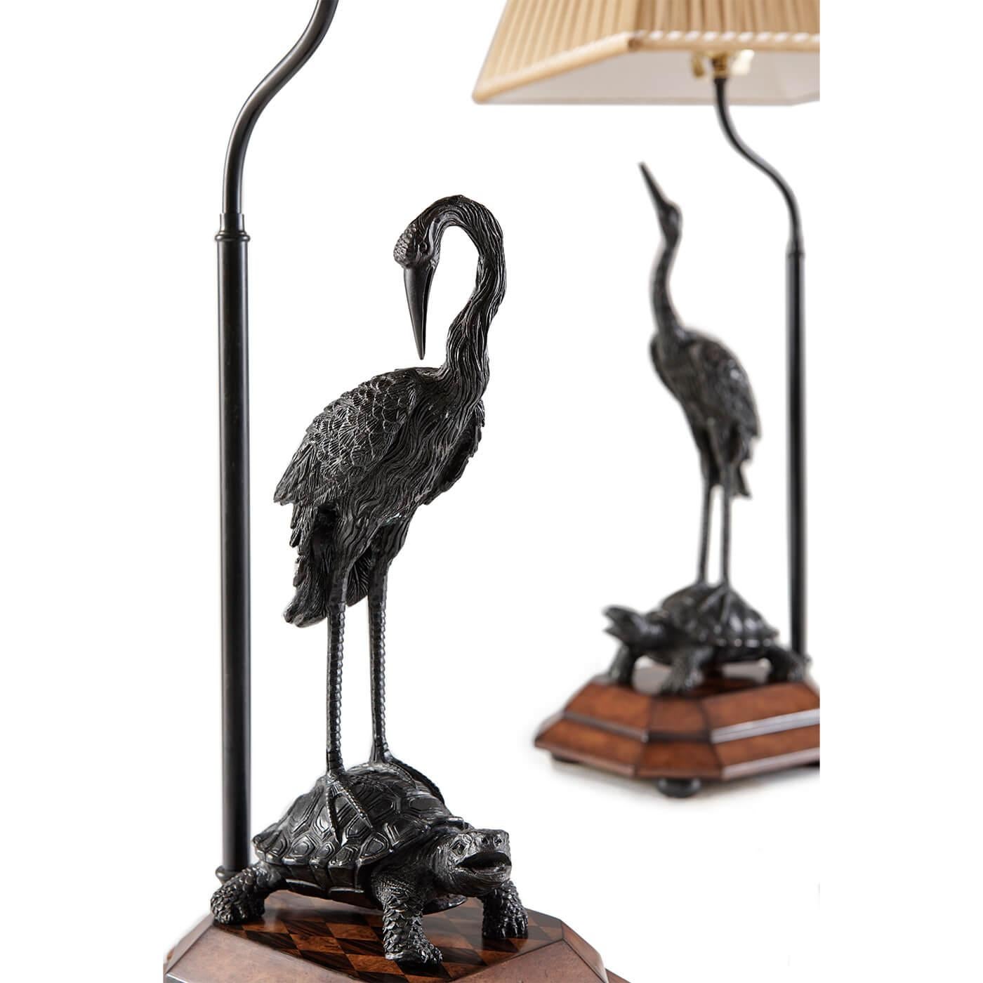 A pair of verdigris brass table lamps, each with a crane standing on a turtle, on burl plinth bases, with pleated silk shades. The originals Japanese Meiji period.

Dimensions: 10