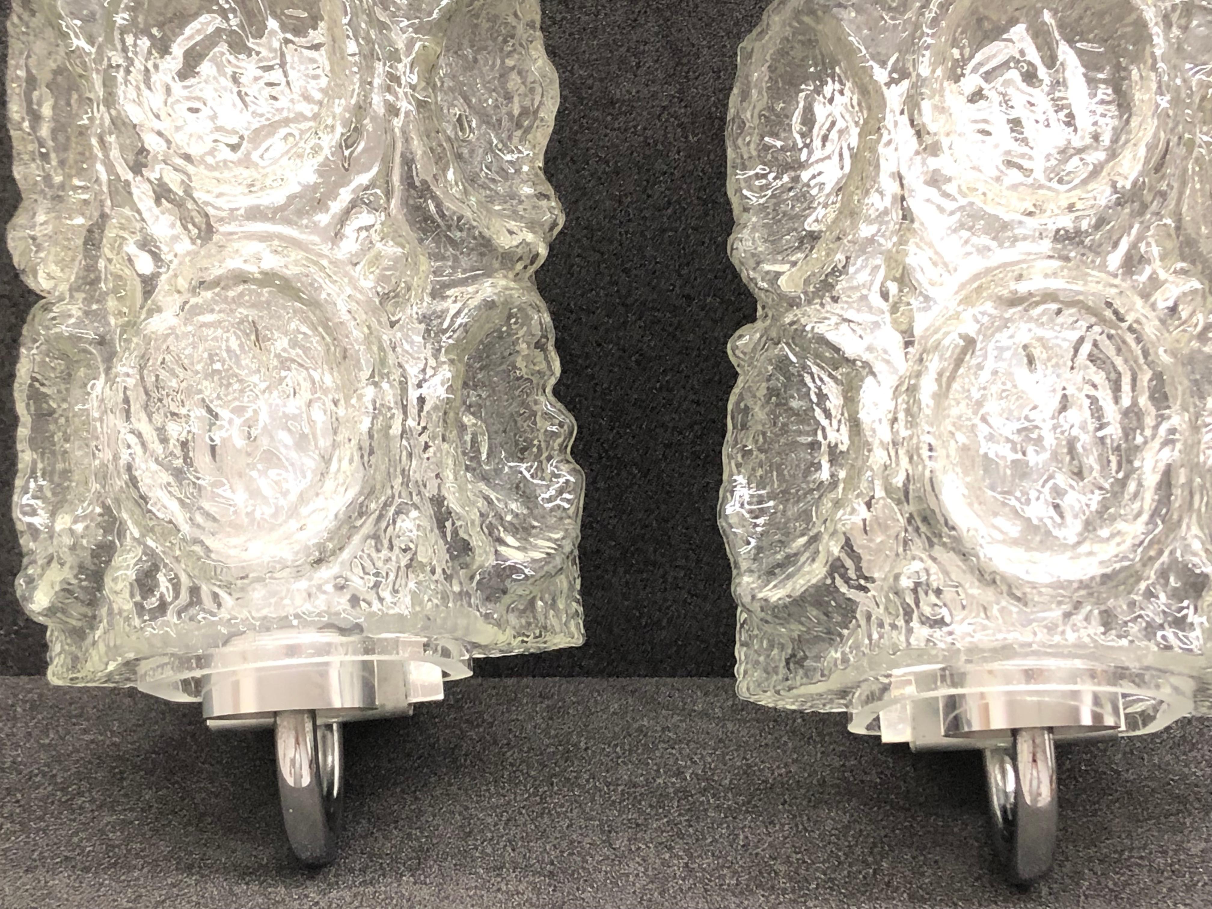 Petite sconces manufactured by Glashütte Limburg. It is a clear tone glass on a chromed metal frame. Each fixture has one European style E27 socket for light bulbs up to 100 watt.